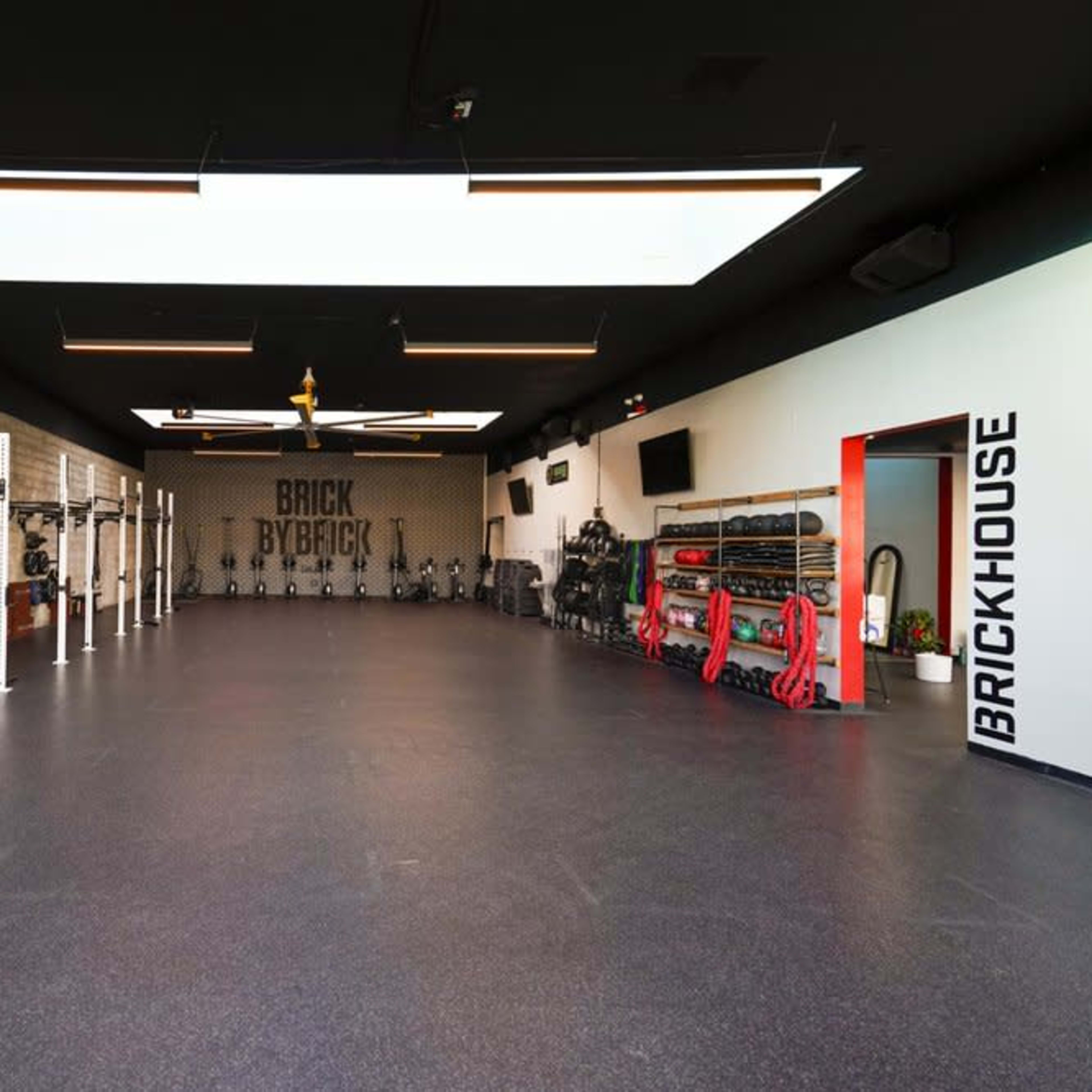A spacious fitness studio equipped with various weightlifting stations and exercise equipment.