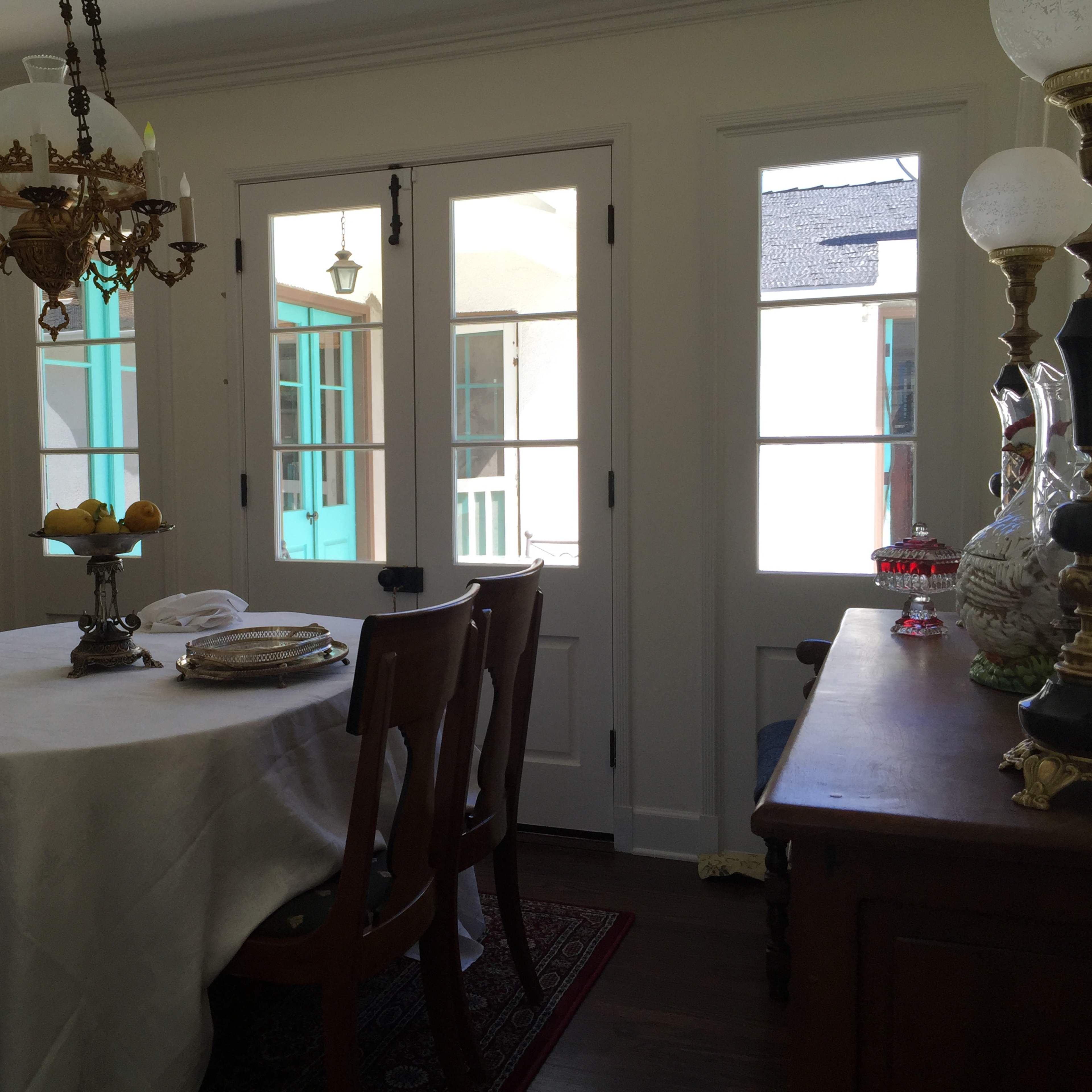 A dining area with a round table set for a meal and large glass doors leading to an outdoor space.