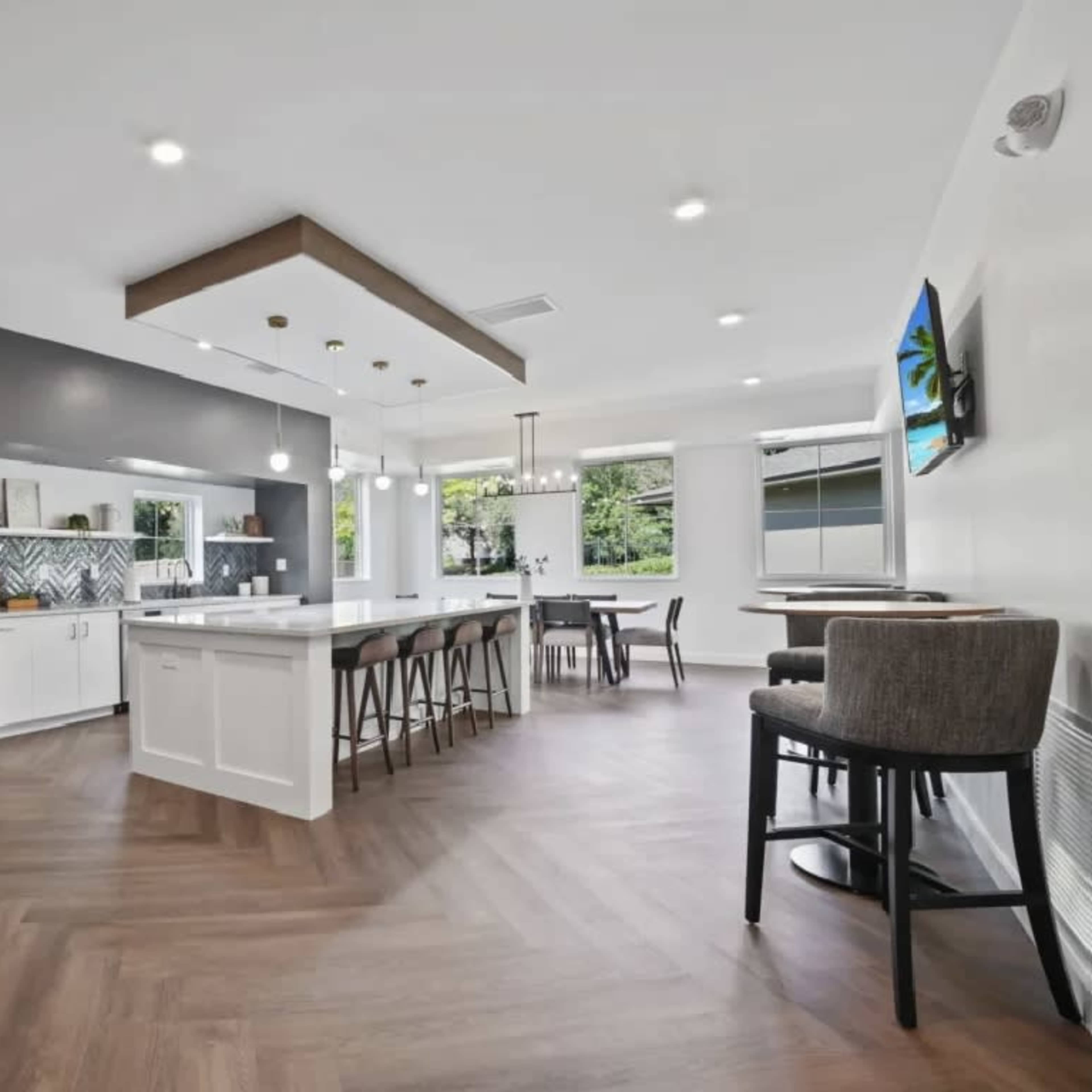 A modern kitchen and dining area featuring spacious countertops, bar seating, and large windows that provide natural light.