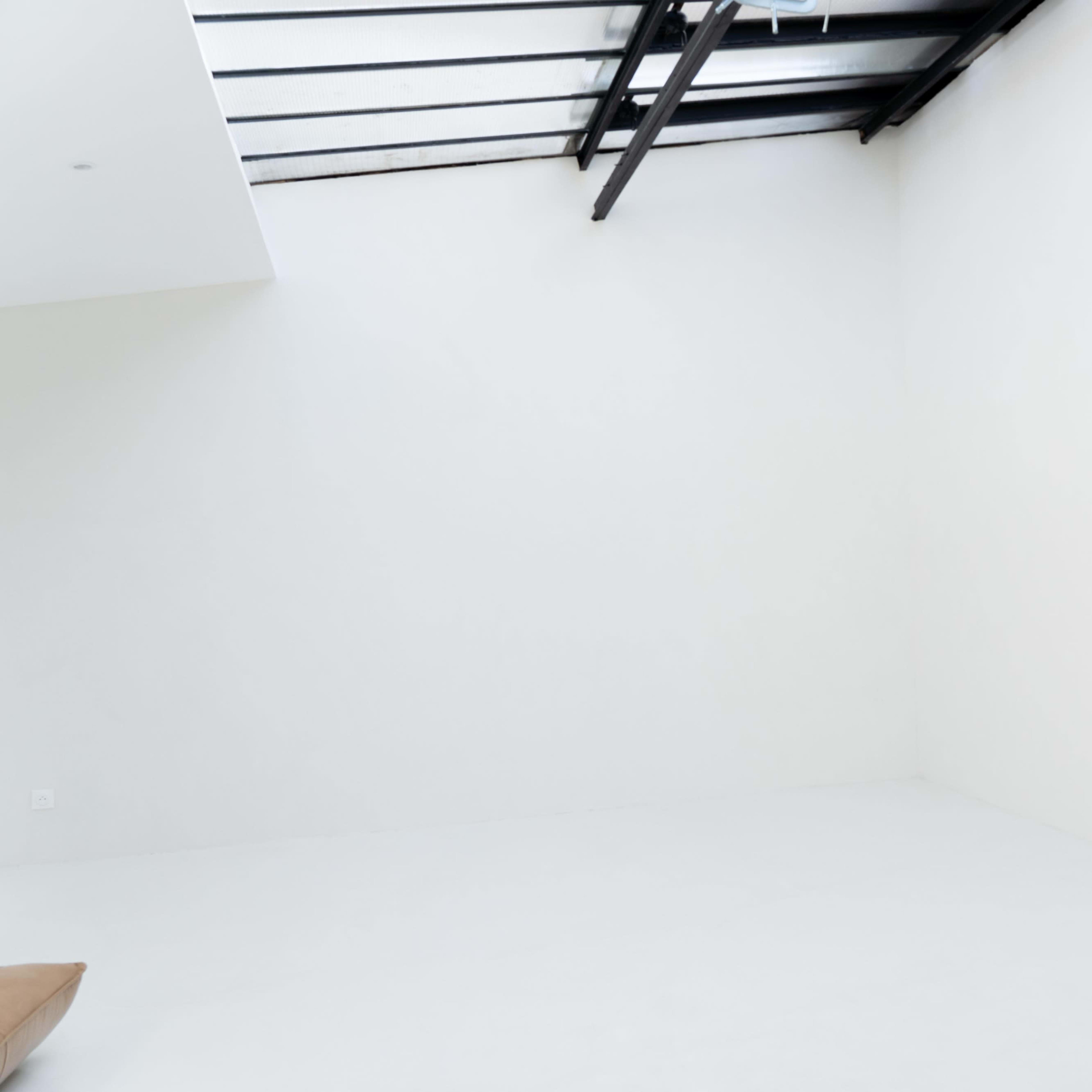 A large, empty room with white walls and a skylight.