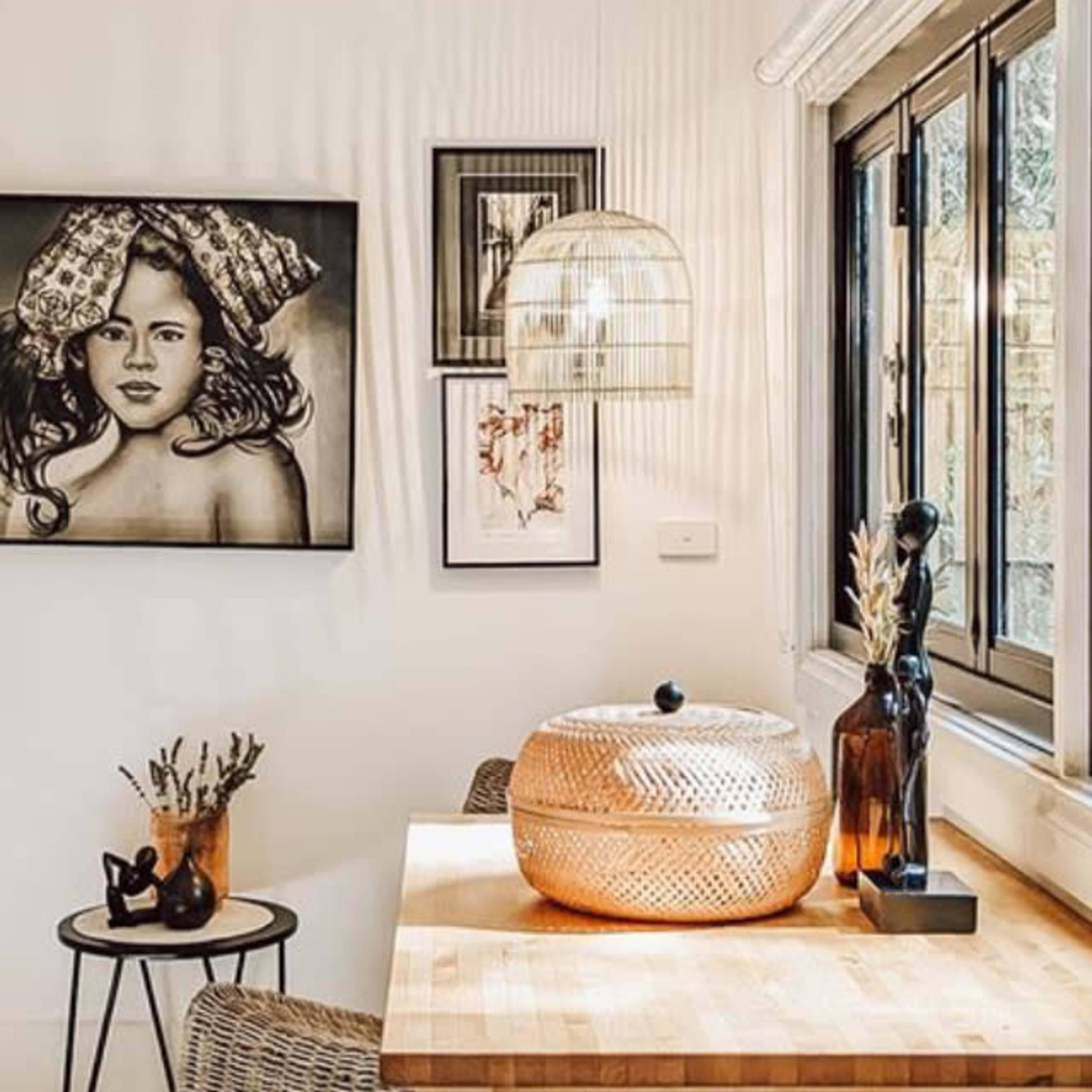 A contemporary kitchen corner featuring a wooden countertop, a decorative bowl, and artwork on the wall.