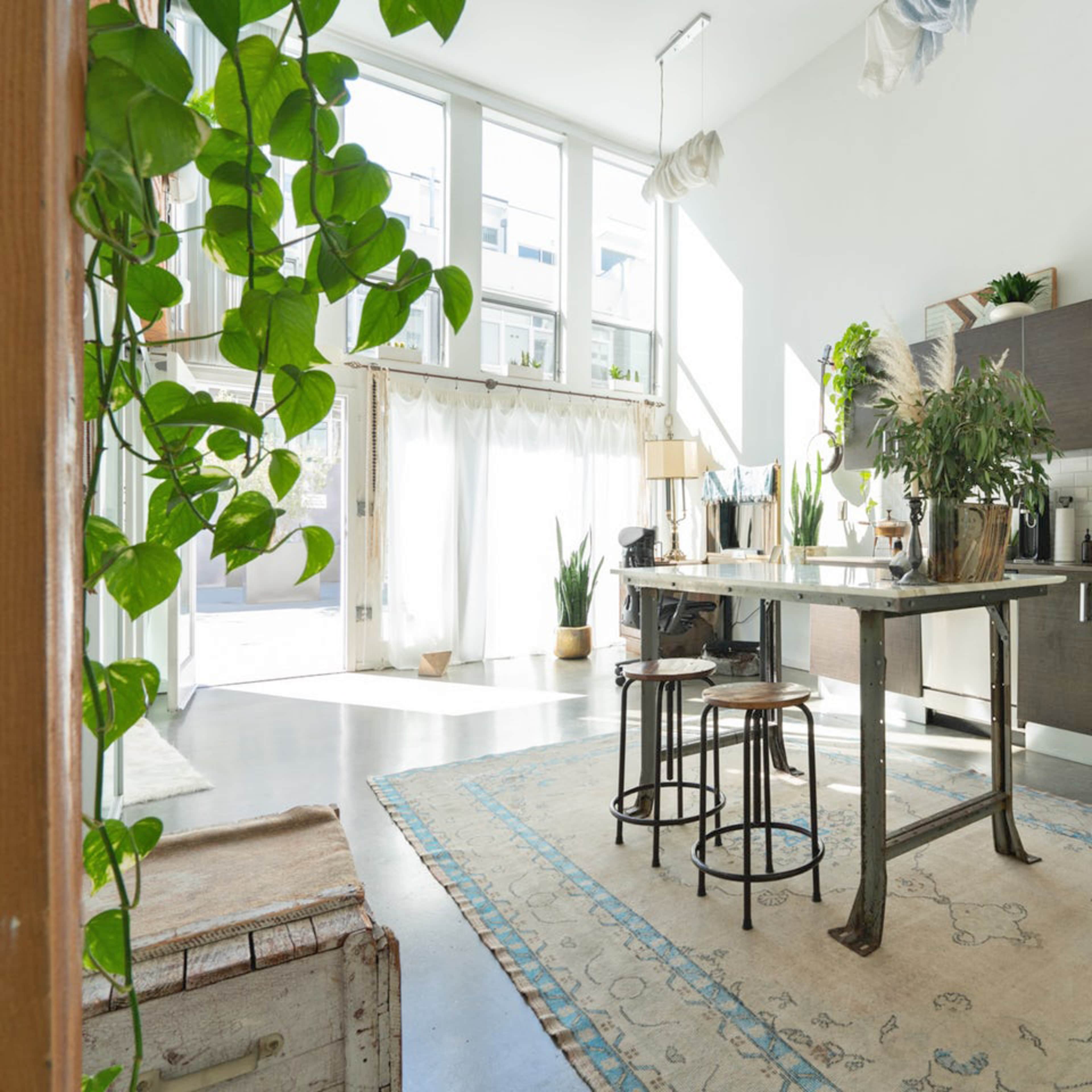 A modern kitchen with a central island, bar stools, and a large window allowing natural light to fill the space.