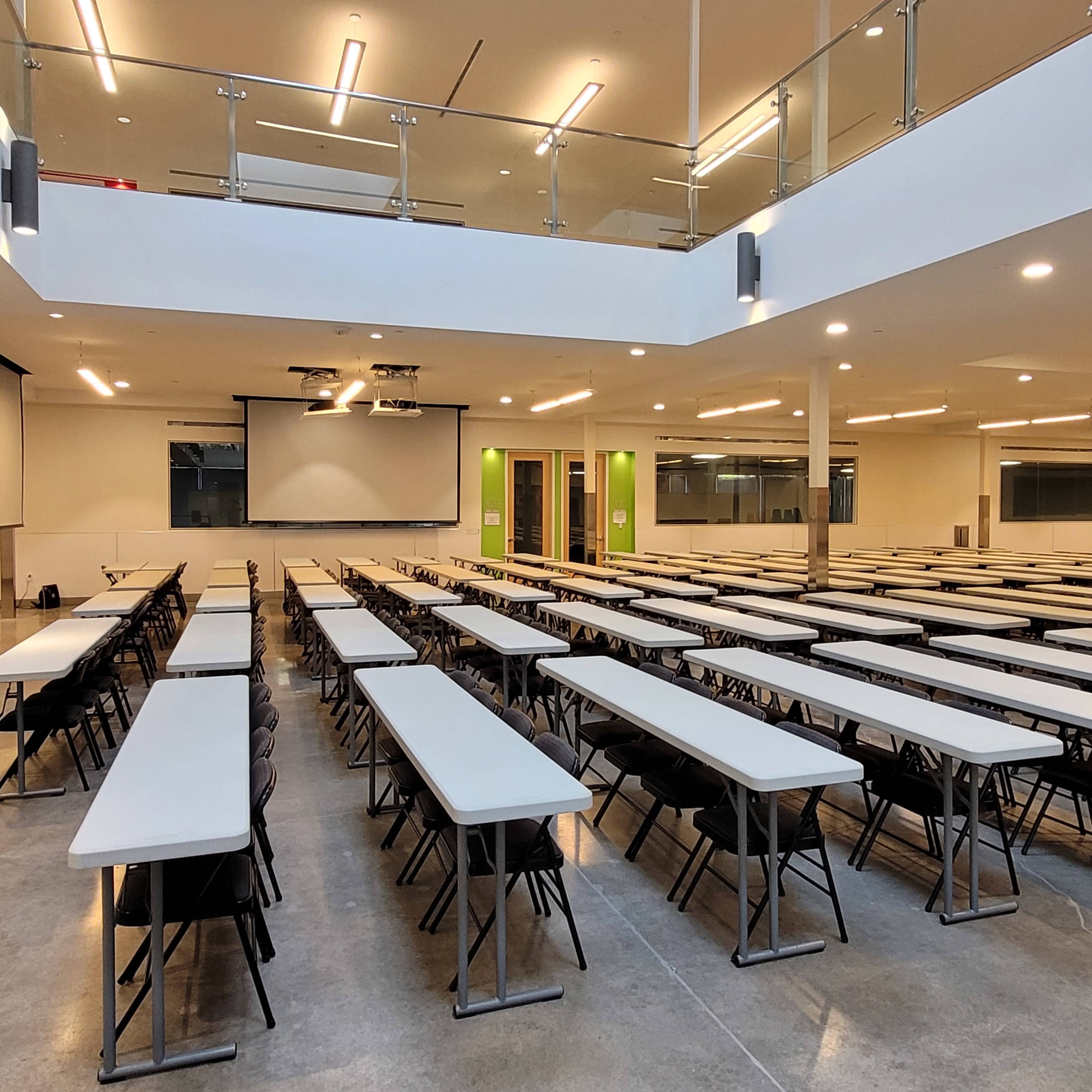 A spacious, modern classroom or event space with rows of tables and chairs arranged for an event.