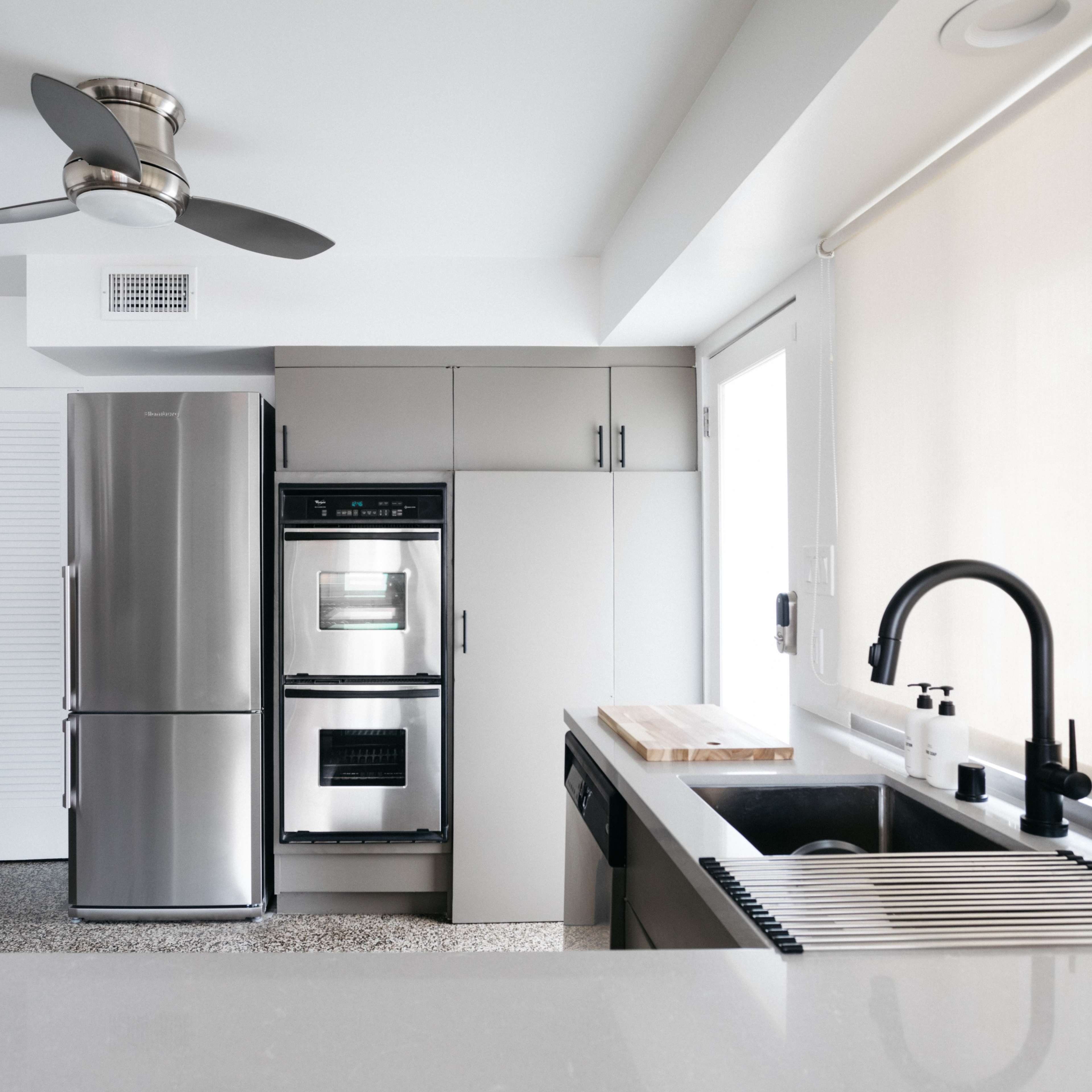A modern kitchen featuring stainless steel appliances, a sleek countertop, and minimalist cabinetry.