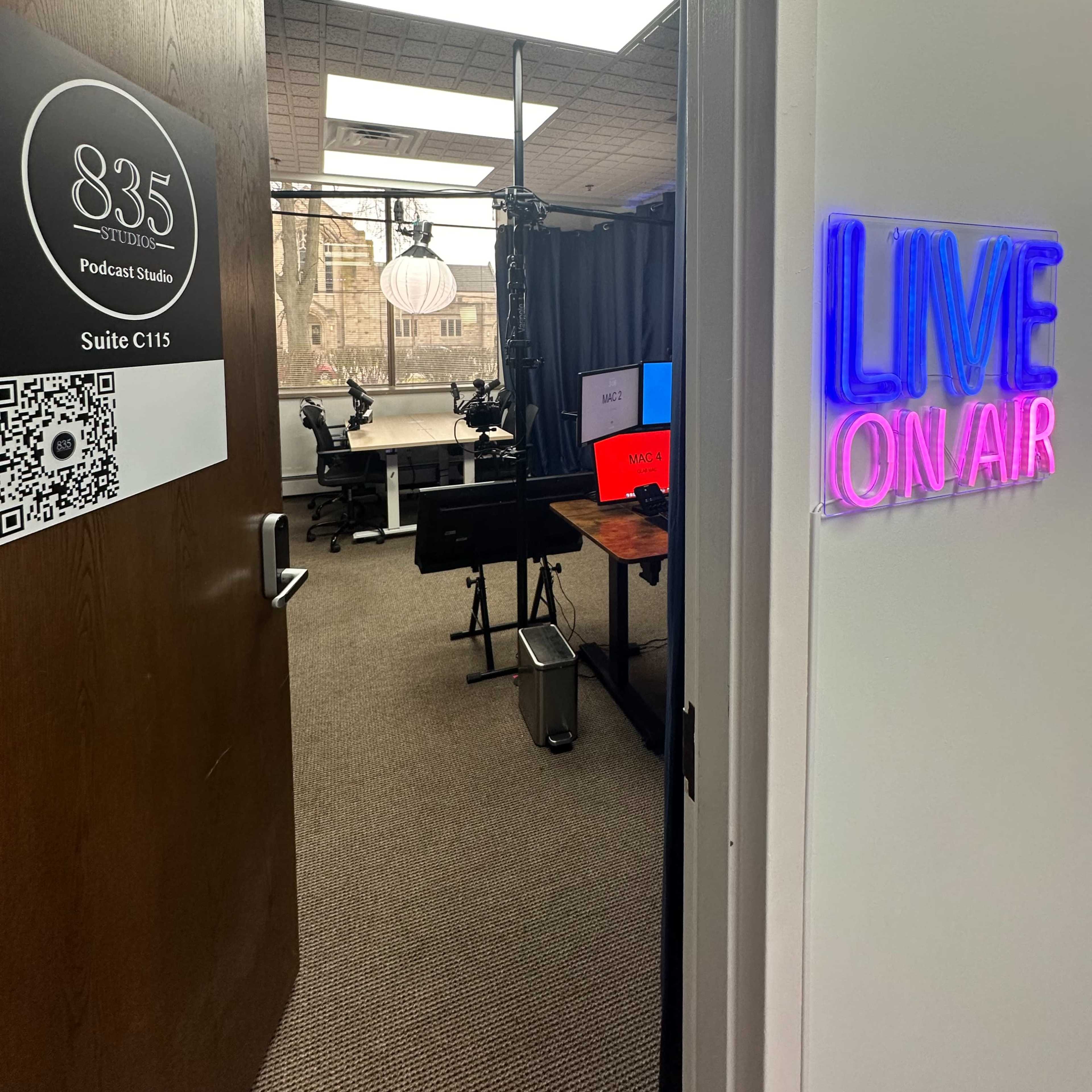 The entrance to a podcast studio with a sign indicating "835 Podcast Studio" and a glowing "LIVE ON AIR" sign alongside the door.