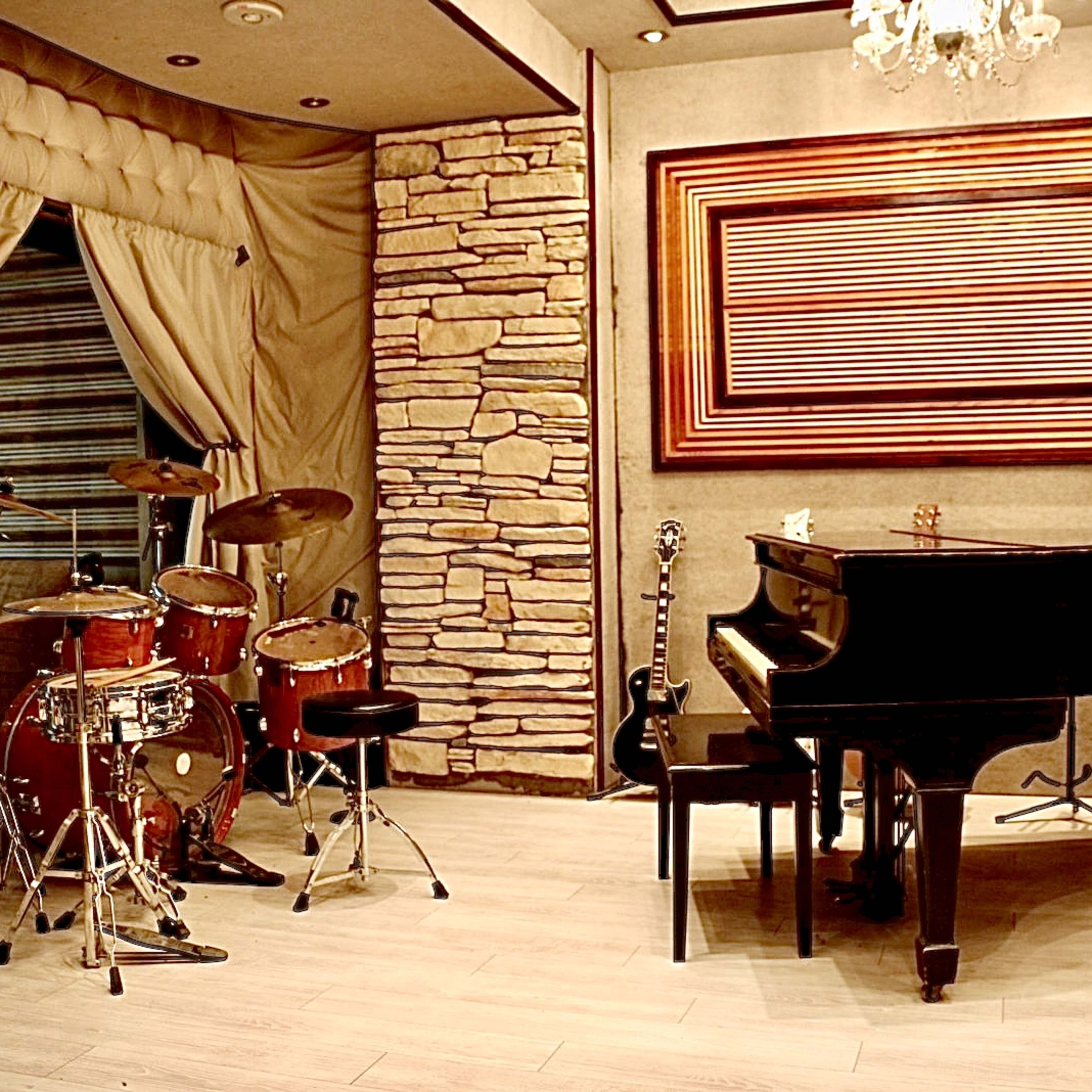 A music room with a grand piano, a drum set, and various musical instruments against a backdrop of stone walls and soft drapery.