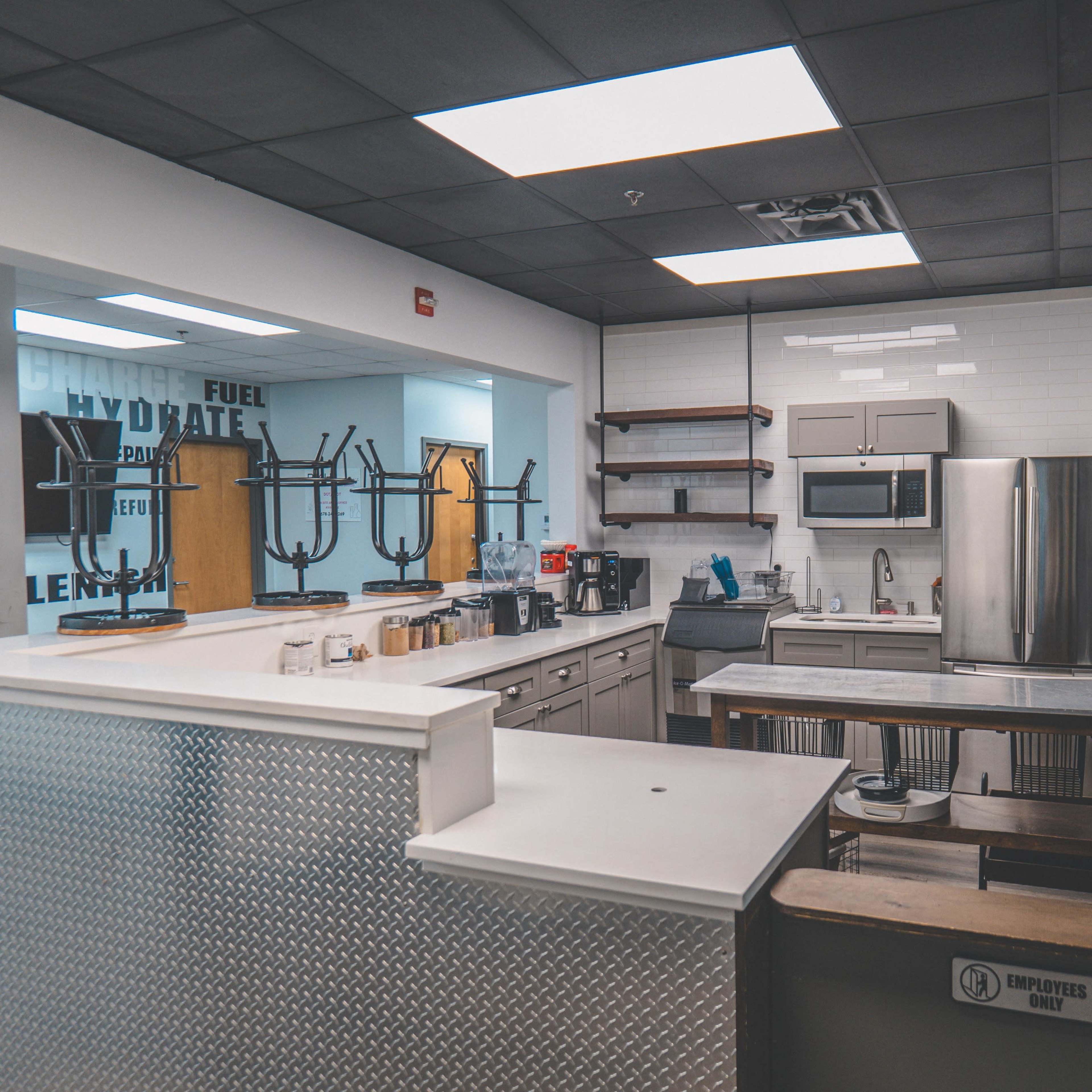 A modern kitchen space equipped with stainless steel appliances, countertops, and various kitchen utensils in a well-lit environment.
