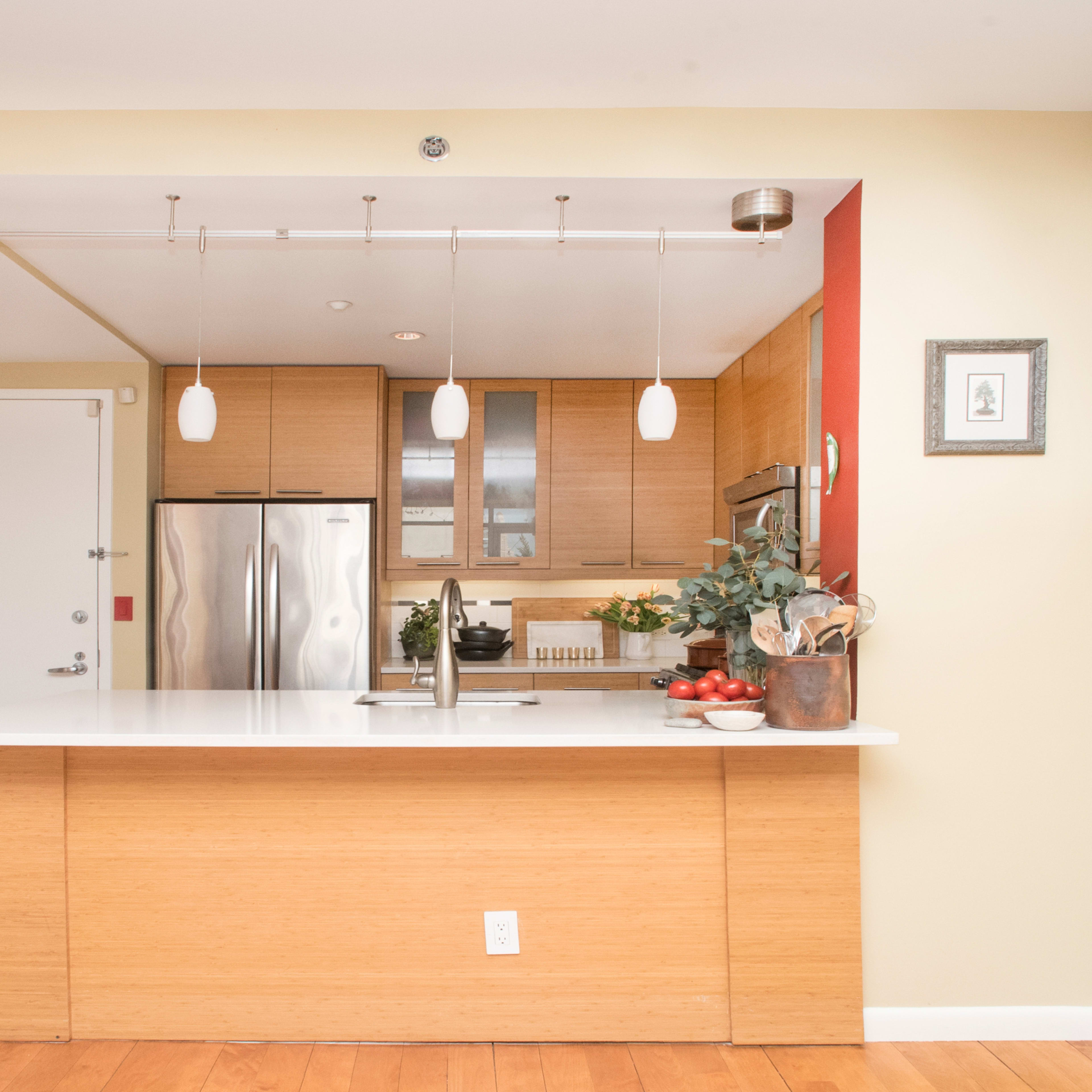 A modern kitchen with a sleek island, stainless steel appliances, and pendant lighting.
