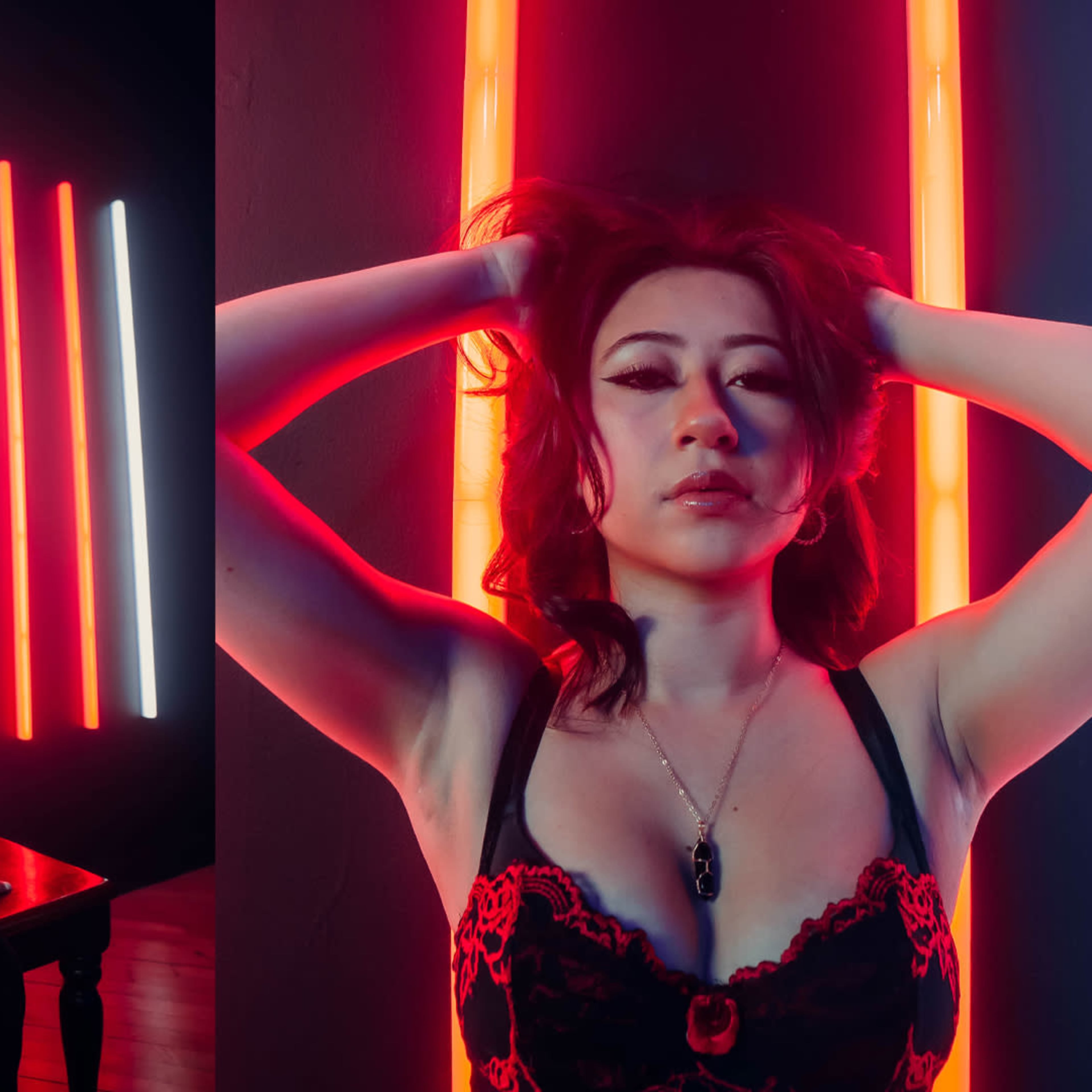 A woman poses in a dimly lit room with vertical neon lights in red and white, one image showing her seated and the other highlighting her upper body.