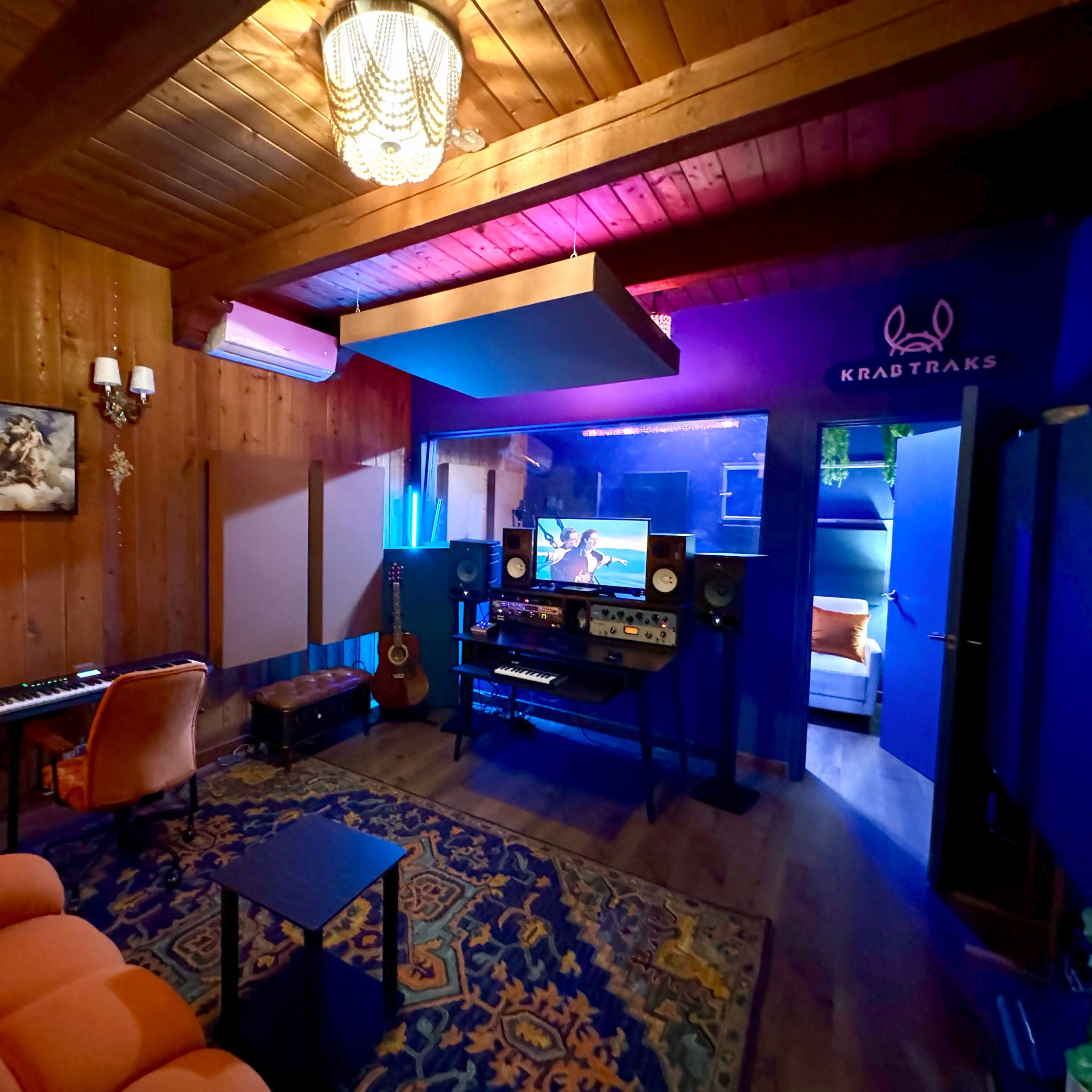 A music studio with wooden walls, a keyboard, and various sound equipment arranged in a cozy atmosphere.