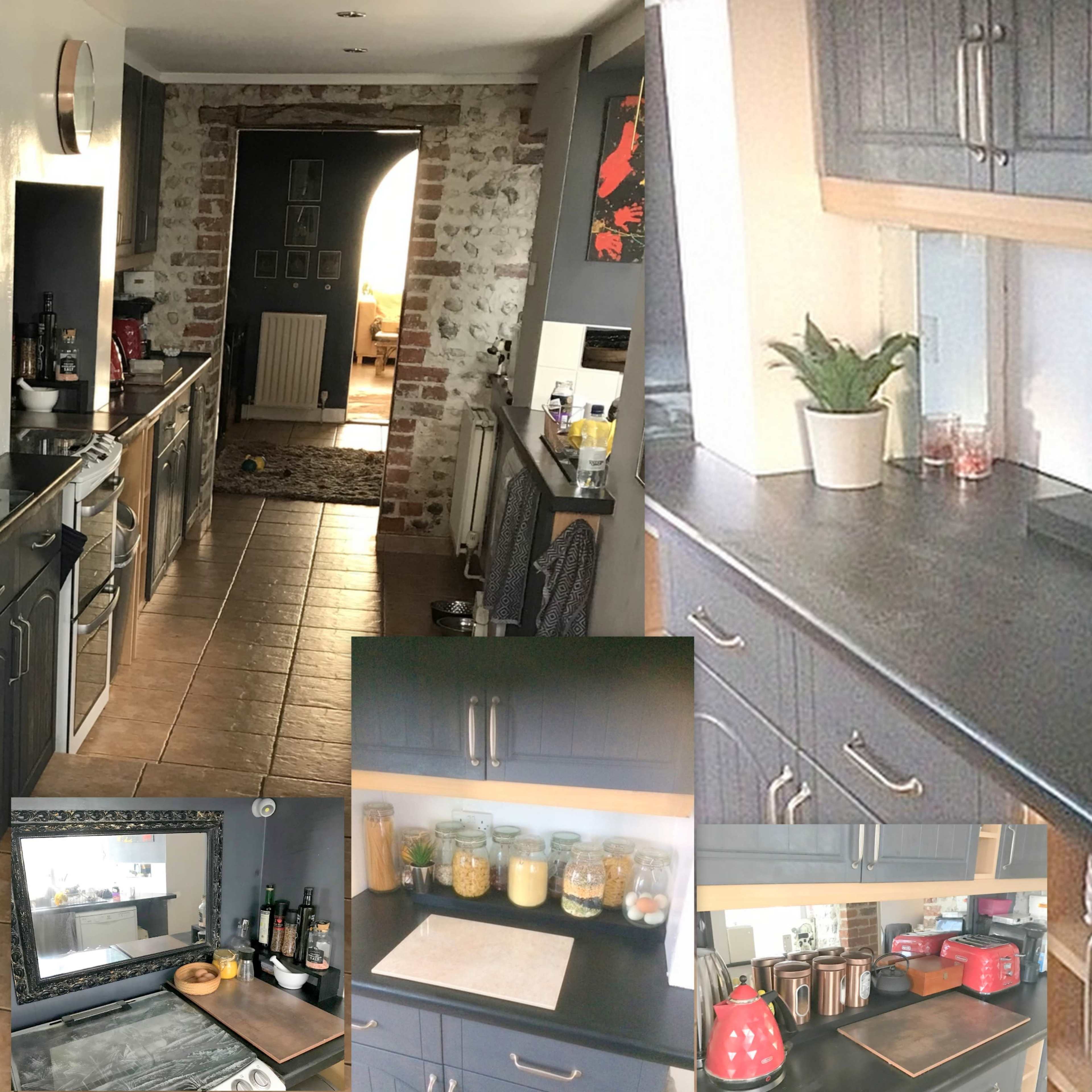 A modern kitchen with dark gray cabinetry, a tiled floor, and a countertop featuring various utensils and pantry items.