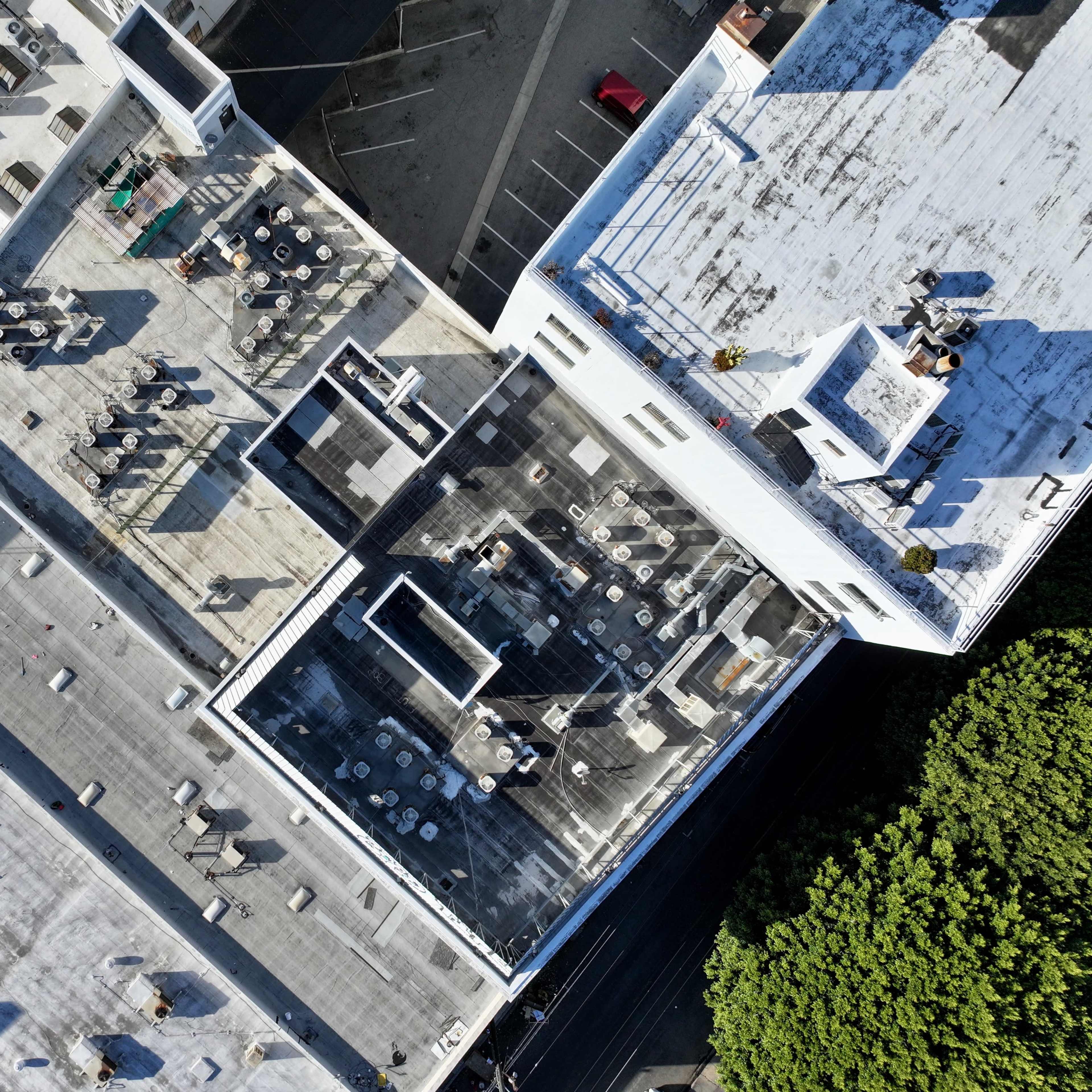 Aerial view of multiple rooftops featuring tables and seating arrangements on a series of flat roofs.