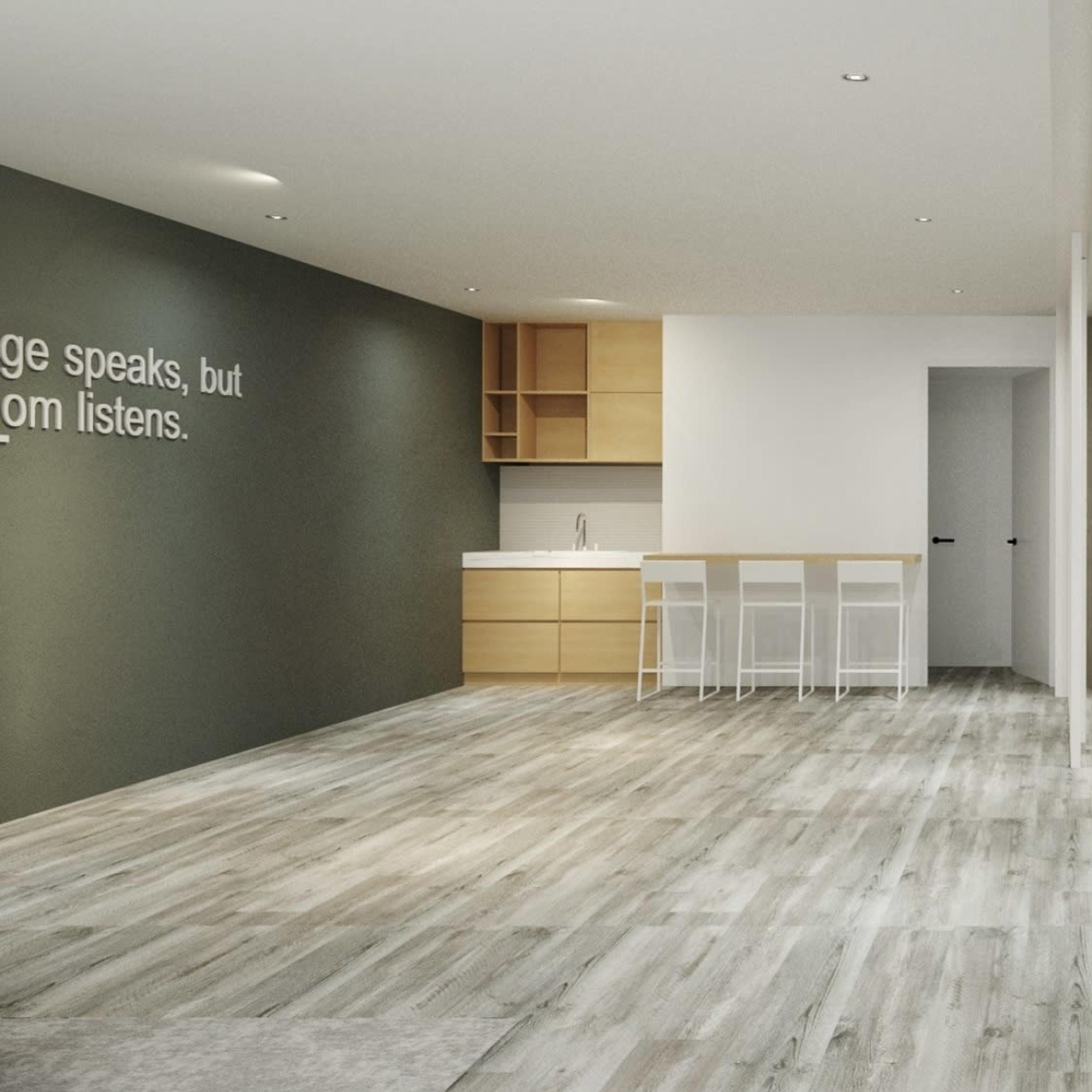 A modern, open-concept kitchen and dining area with light-colored wooden flooring and minimalist furniture.