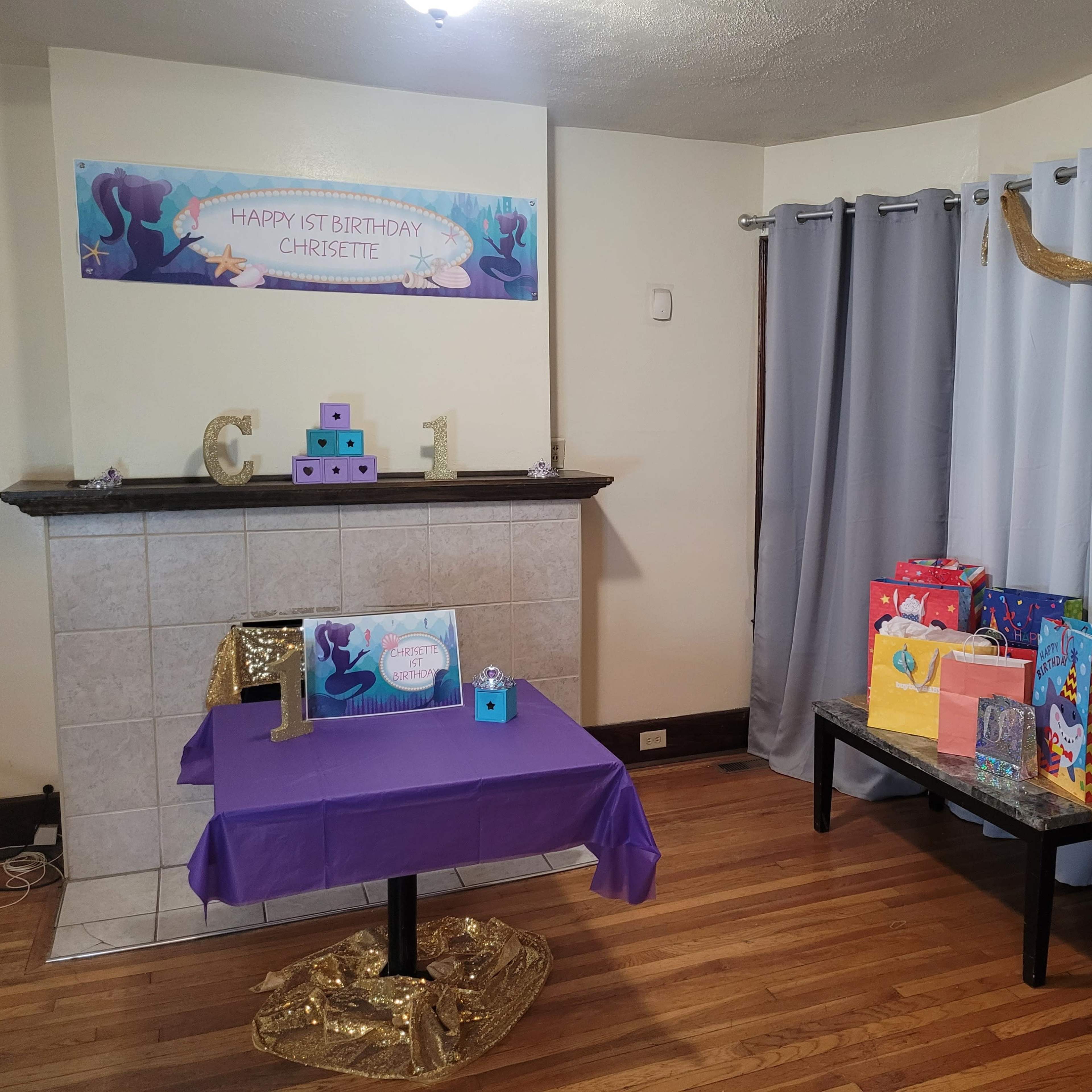 A decorated room for a birthday party, featuring a banner, gifts on a table, and a party-themed setup with tablecloths and decorations.