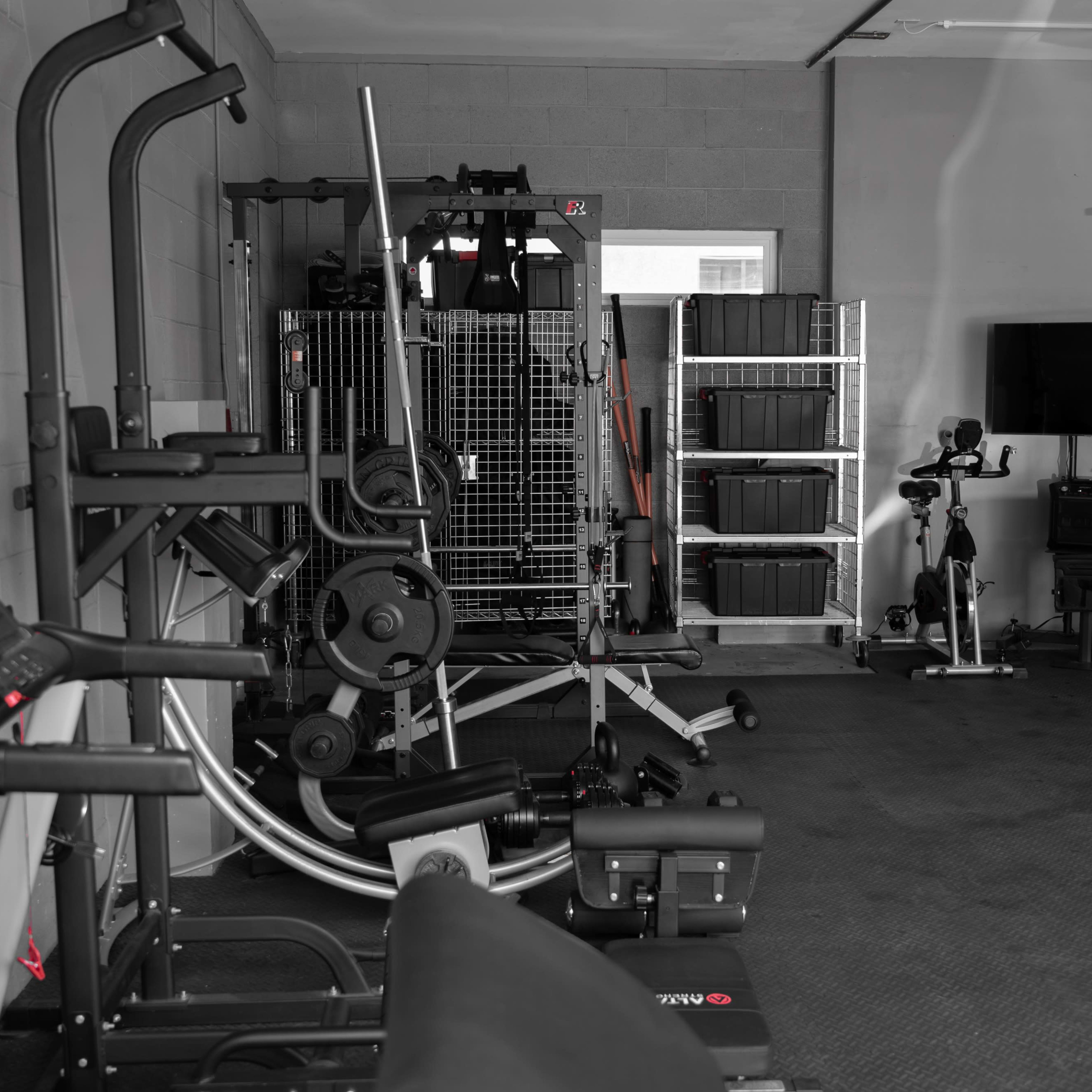 A home gym equipped with various exercise machines and storage units.