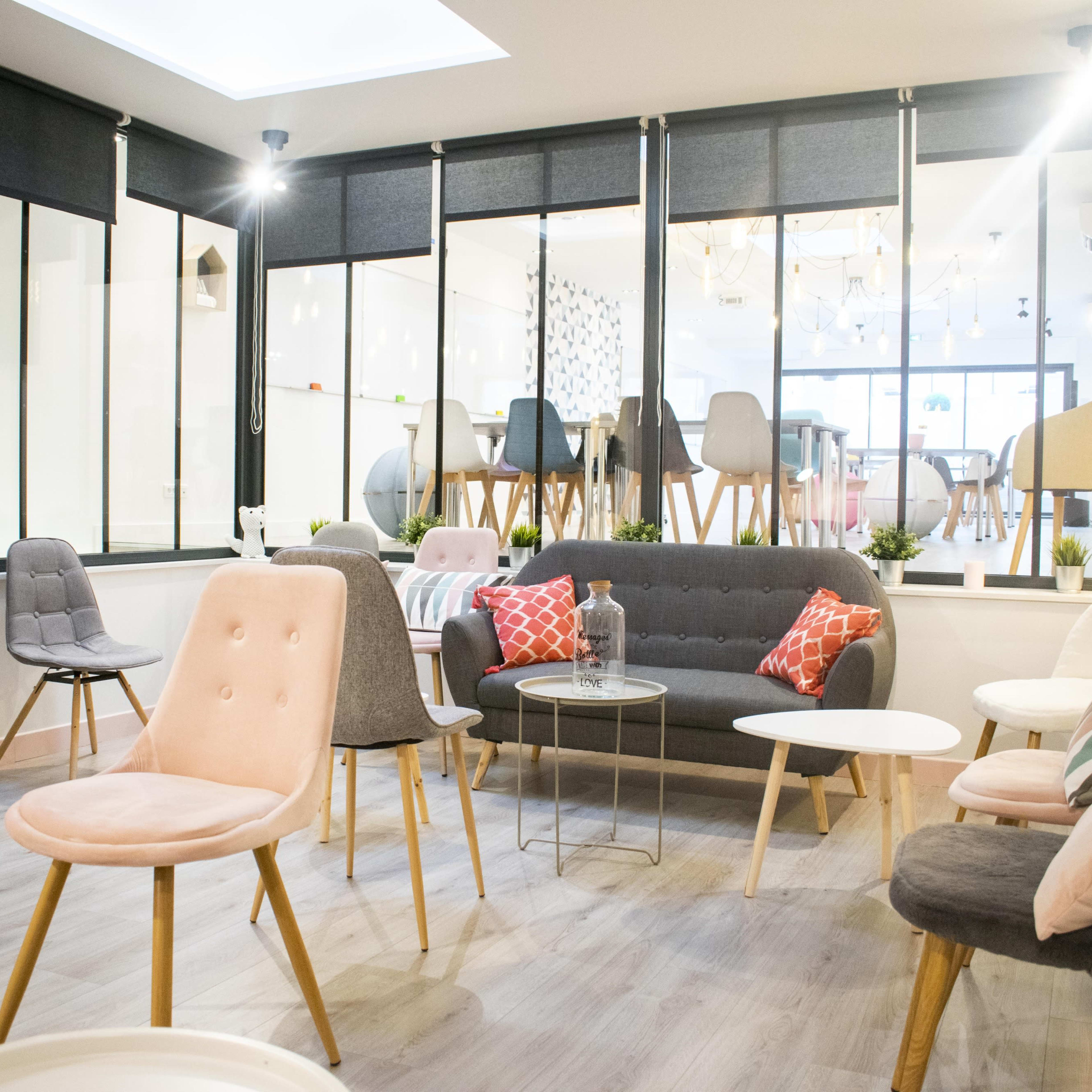A modern seating area with various chairs and small tables arranged in a bright, spacious room.