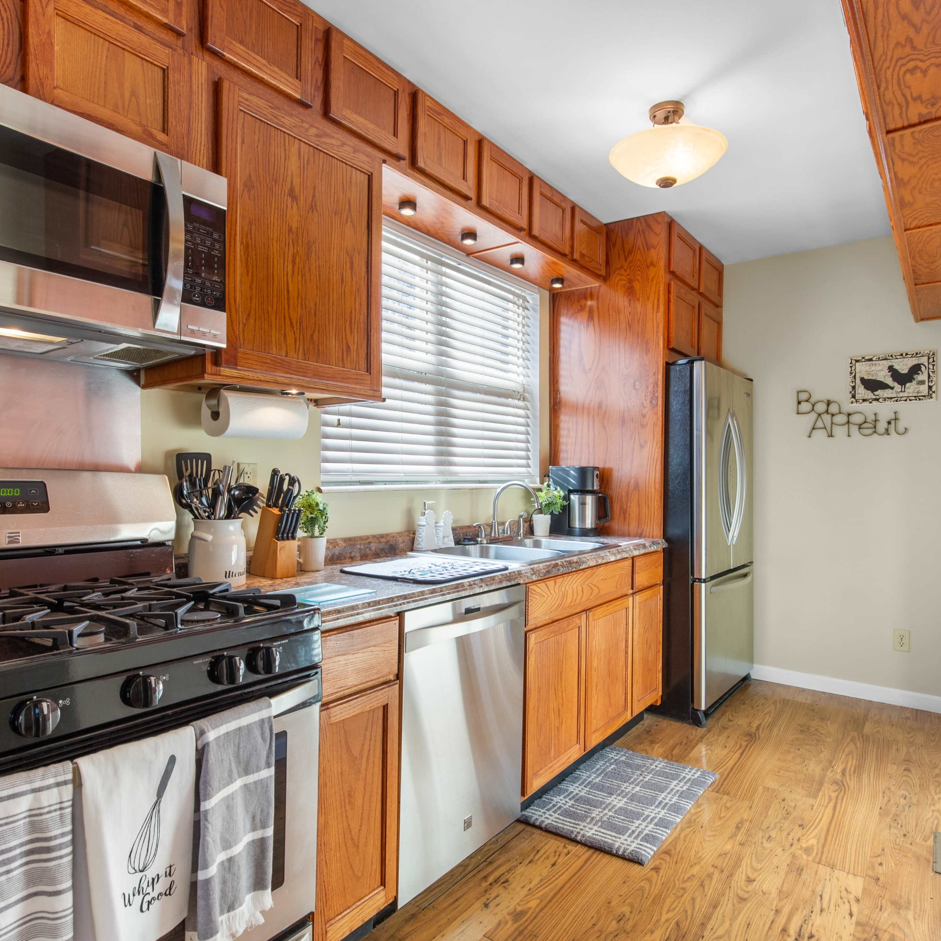 A kitchen with wooden cabinets, stainless steel appliances, and a window providing natural light.