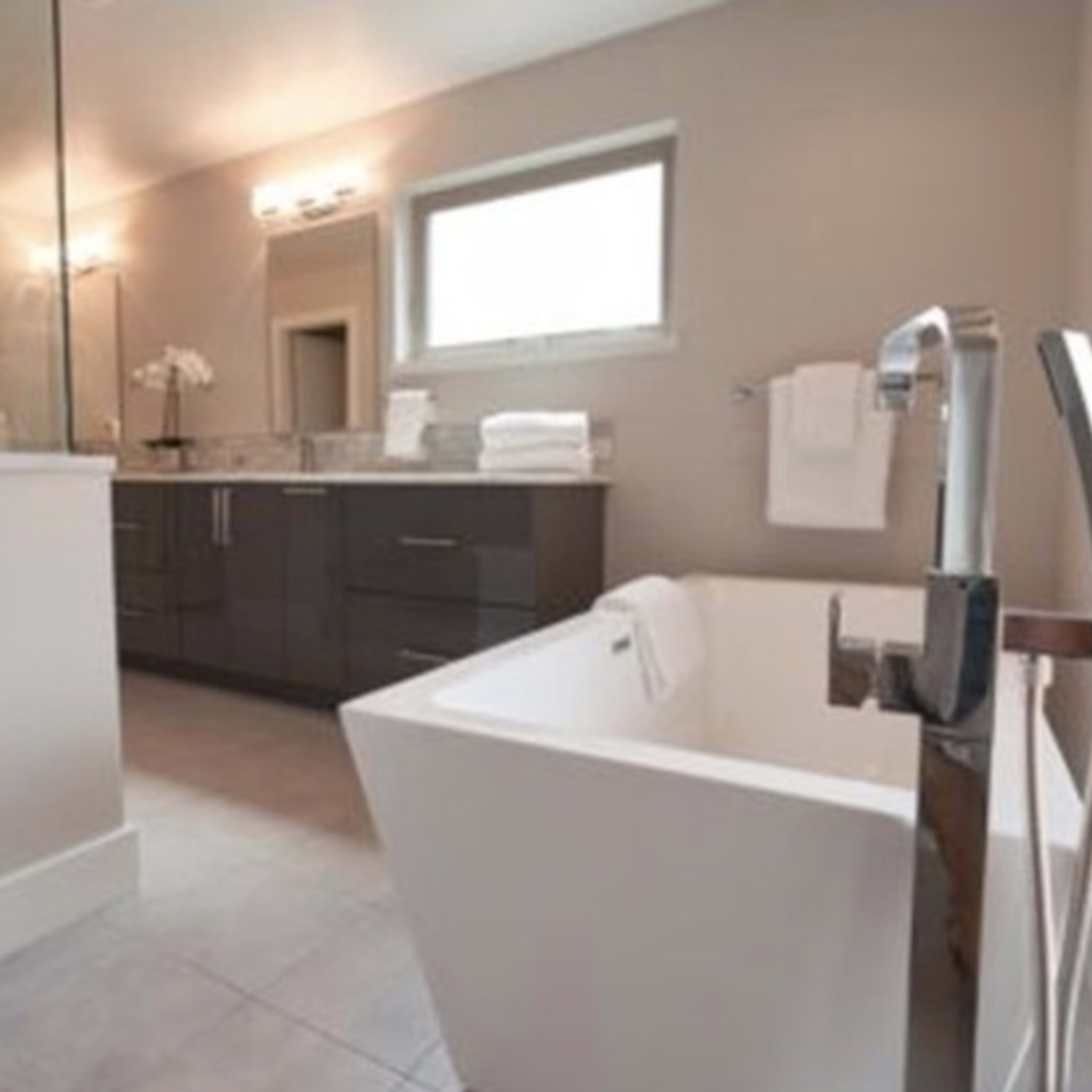 A modern bathroom featuring a freestanding bathtub, a double sink vanity, and a glass shower enclosure.