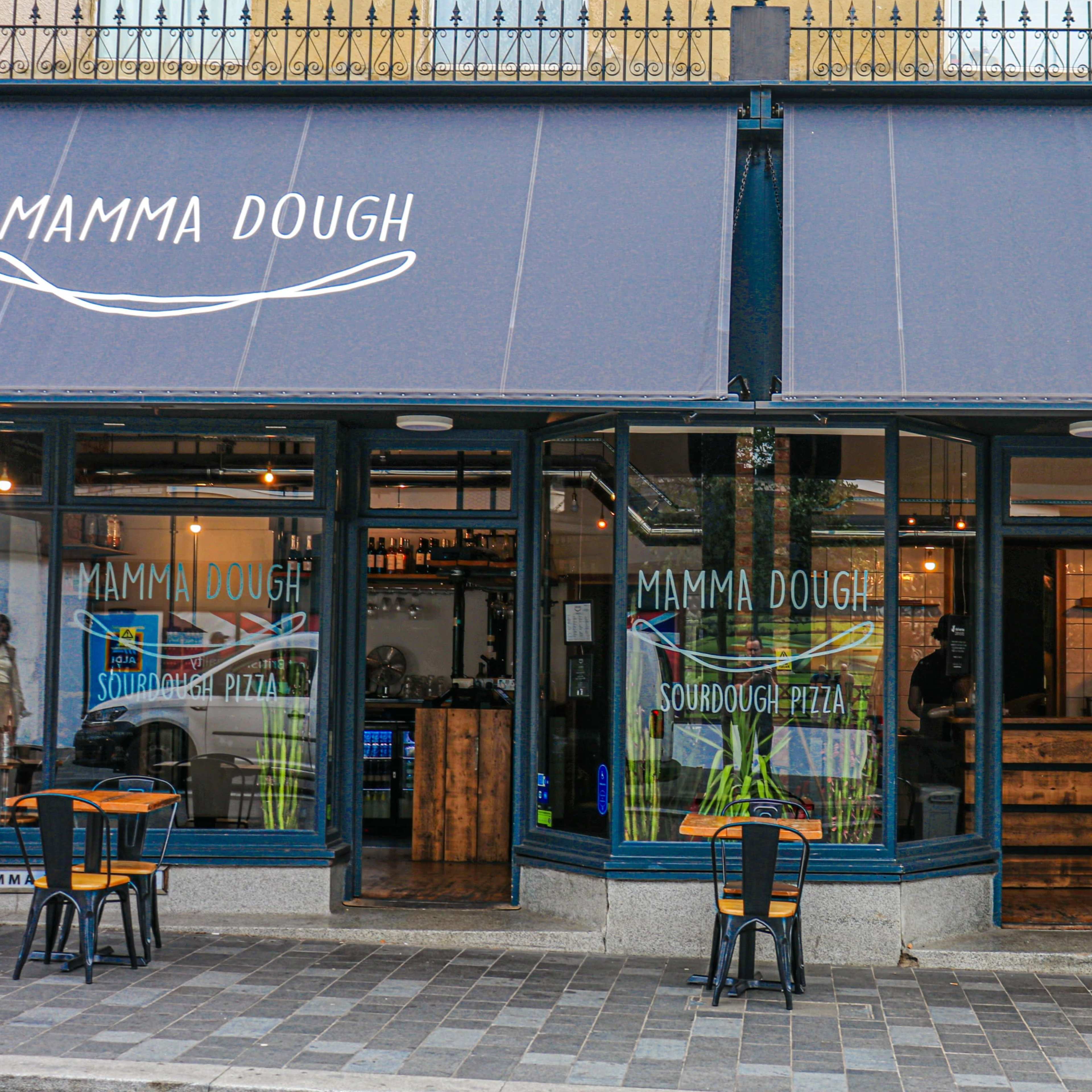 Rustic pizza restaurant with high ceilings and windows spanning the venue. Image in South Norwood, London, England