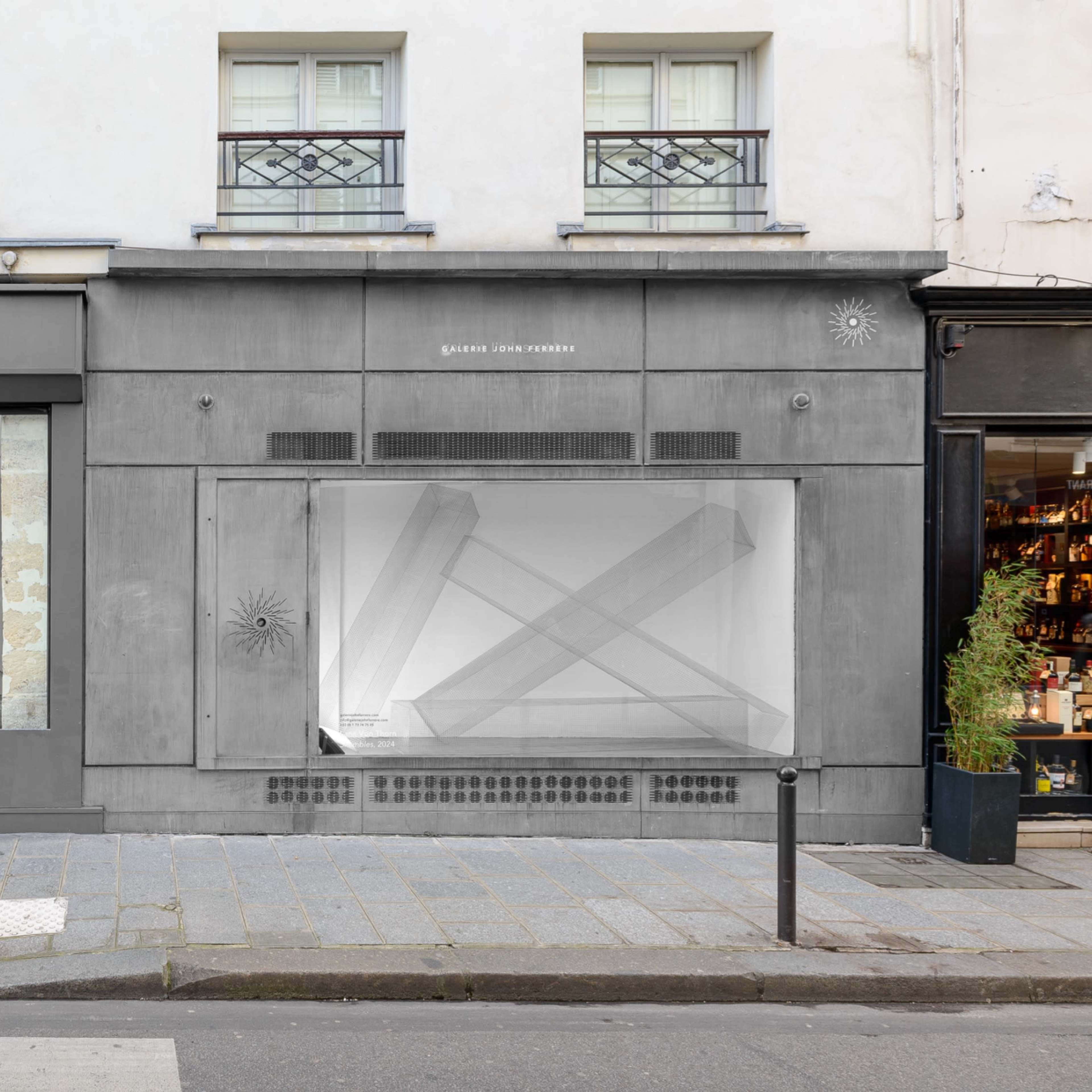 A storefront with a modern design featuring large glass windows on a street in Paris, showcasing a minimalist display inside.