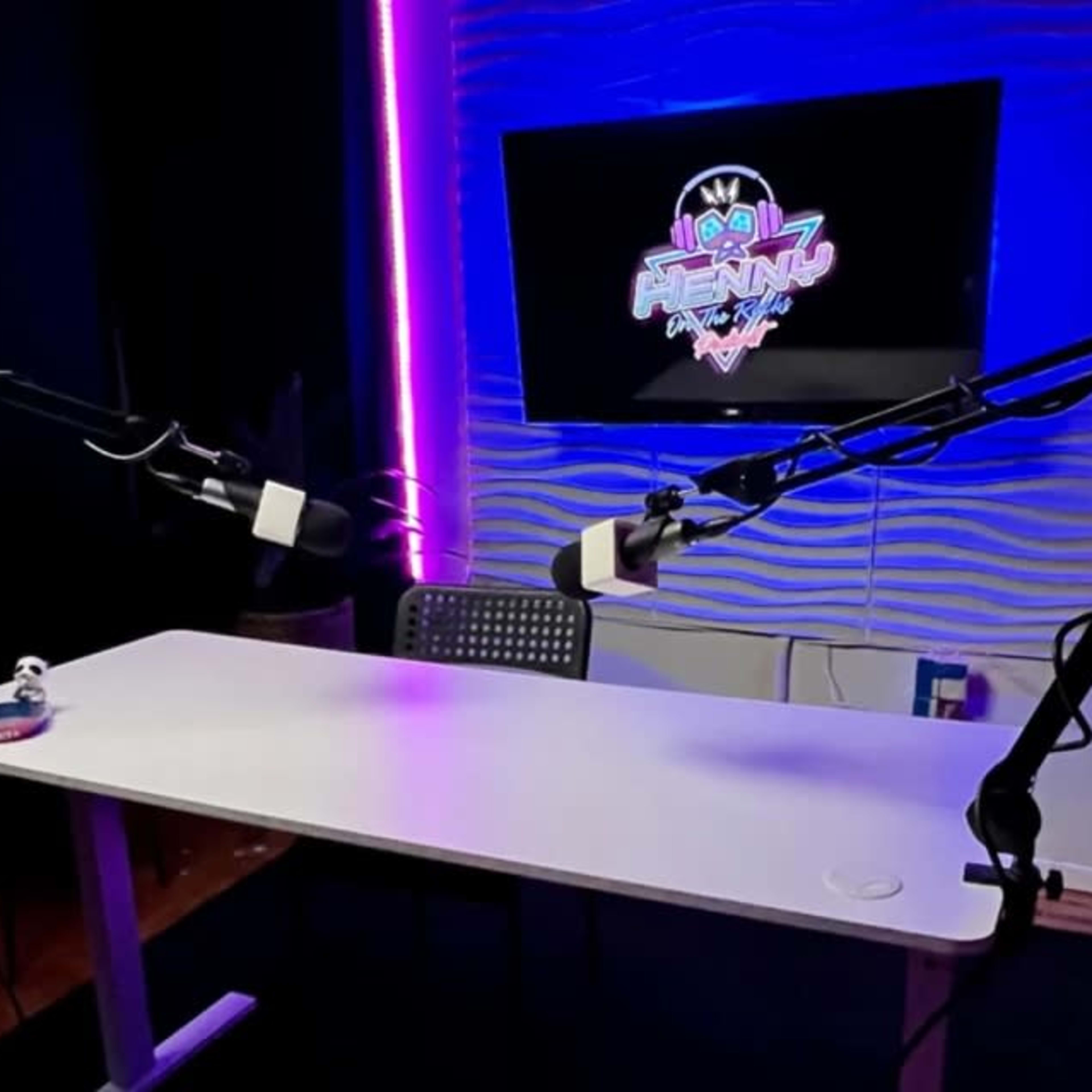 A well-lit podcast studio with a sleek white table and two adjustable microphone arms positioned for recording.