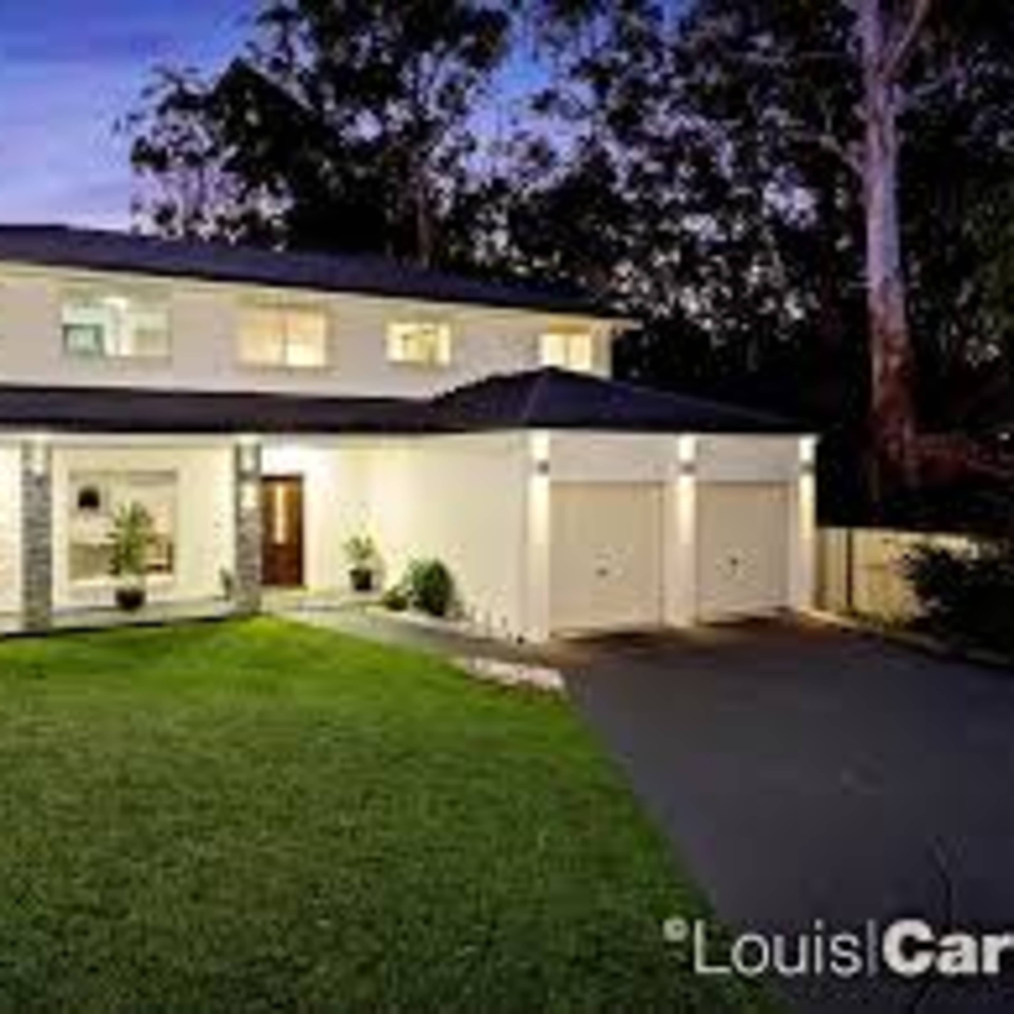 A modern two-story house with a neatly landscaped front yard and a double garage.