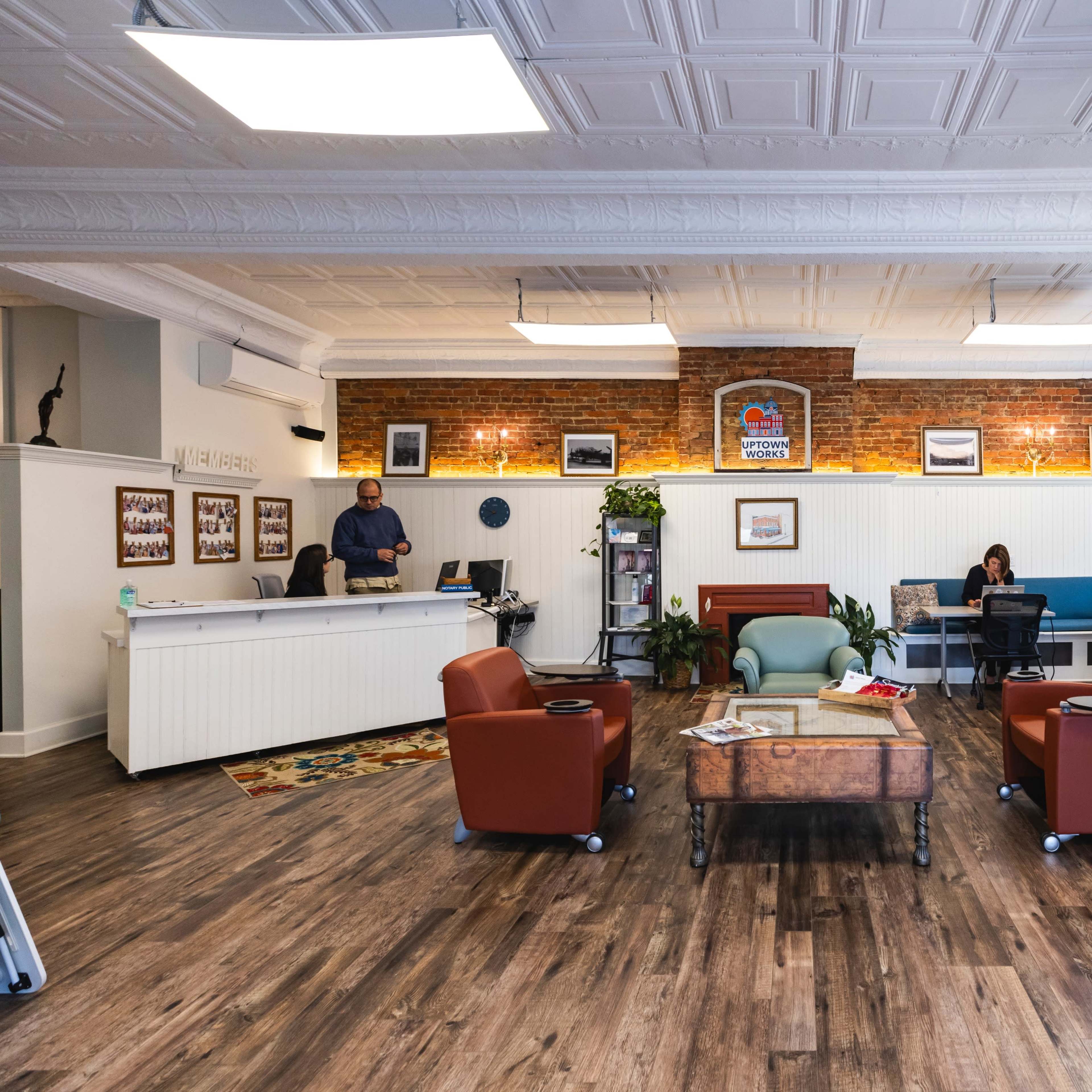 A modern office space with a reception area, seating arrangement, and both natural and artificial lighting.