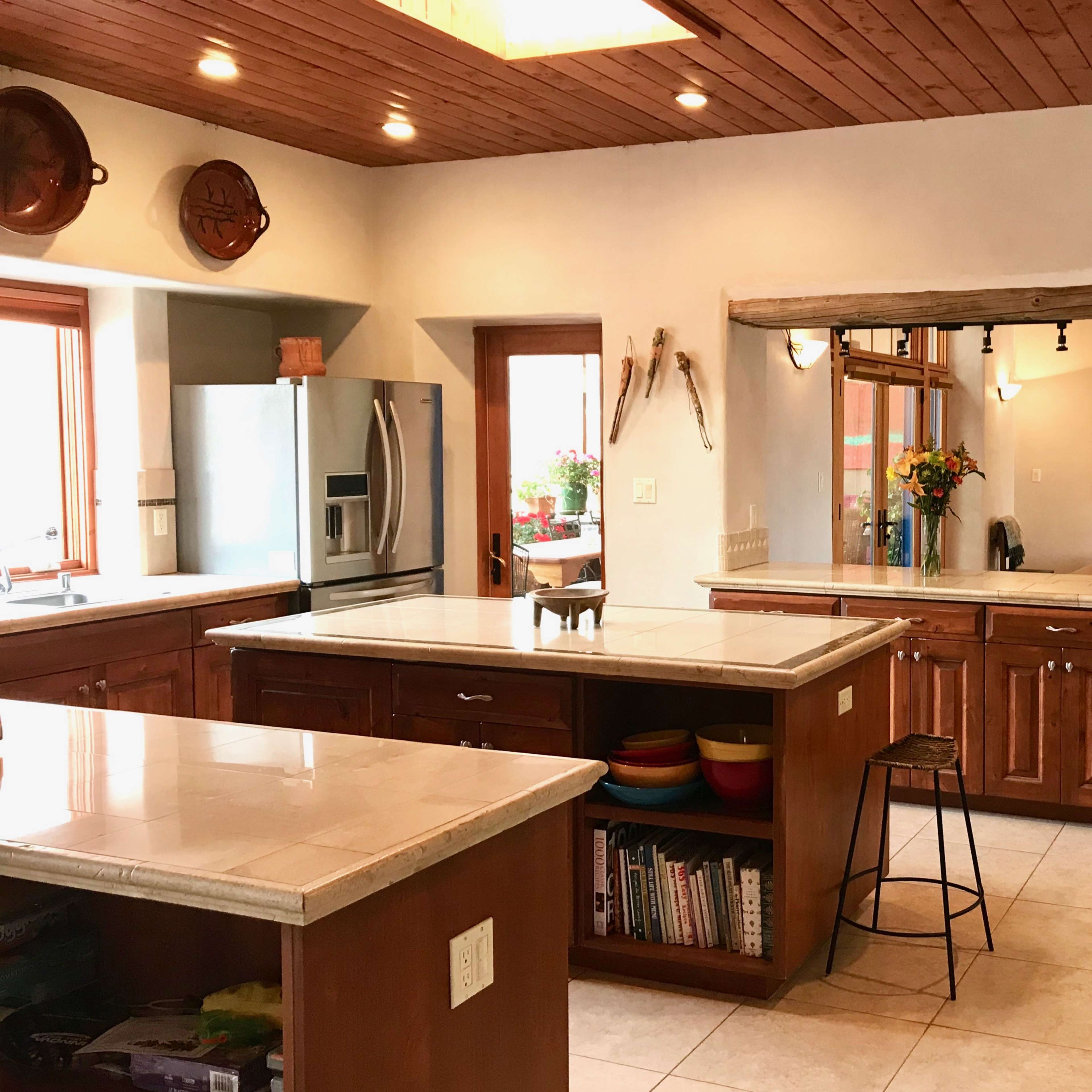 A spacious kitchen with wooden cabinets and countertops, featuring stainless steel appliances and a breakfast bar.