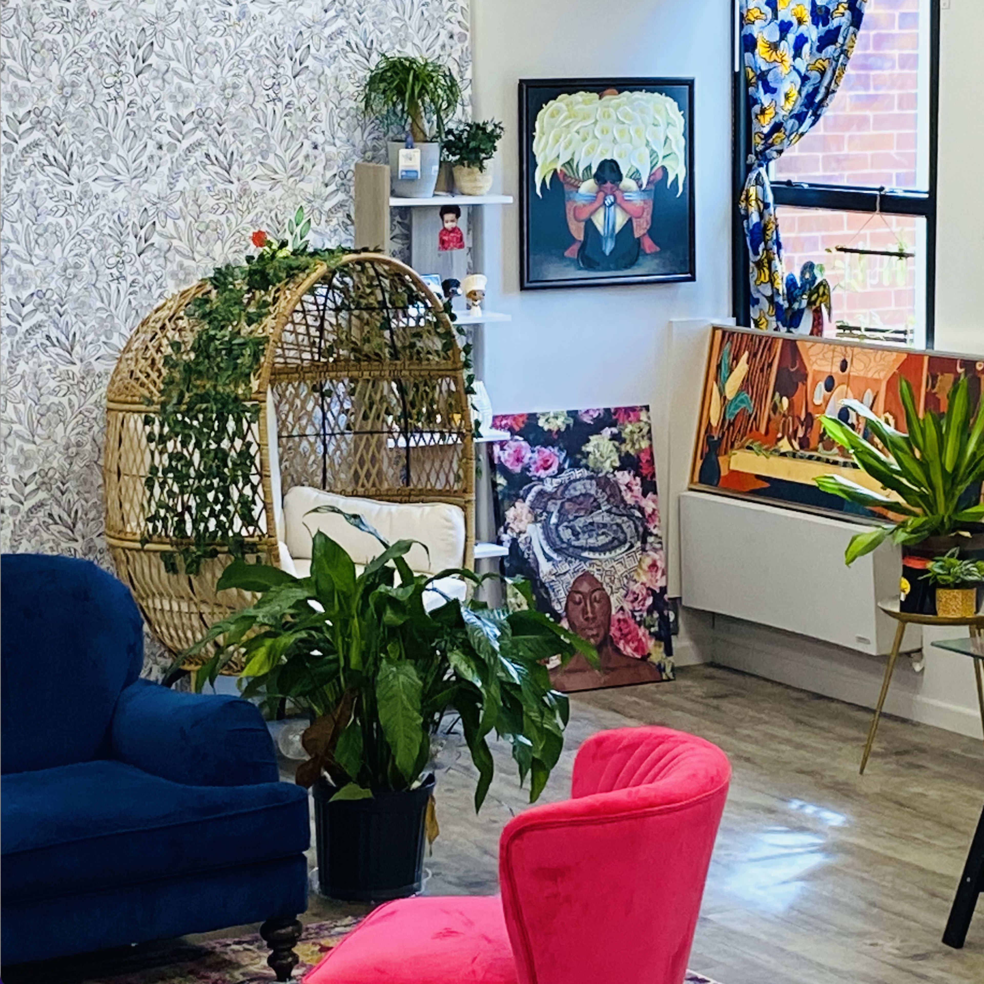 The scene features a modern interior with a blue couch, a pink chair, various plants, and colorful artwork displayed on the walls.