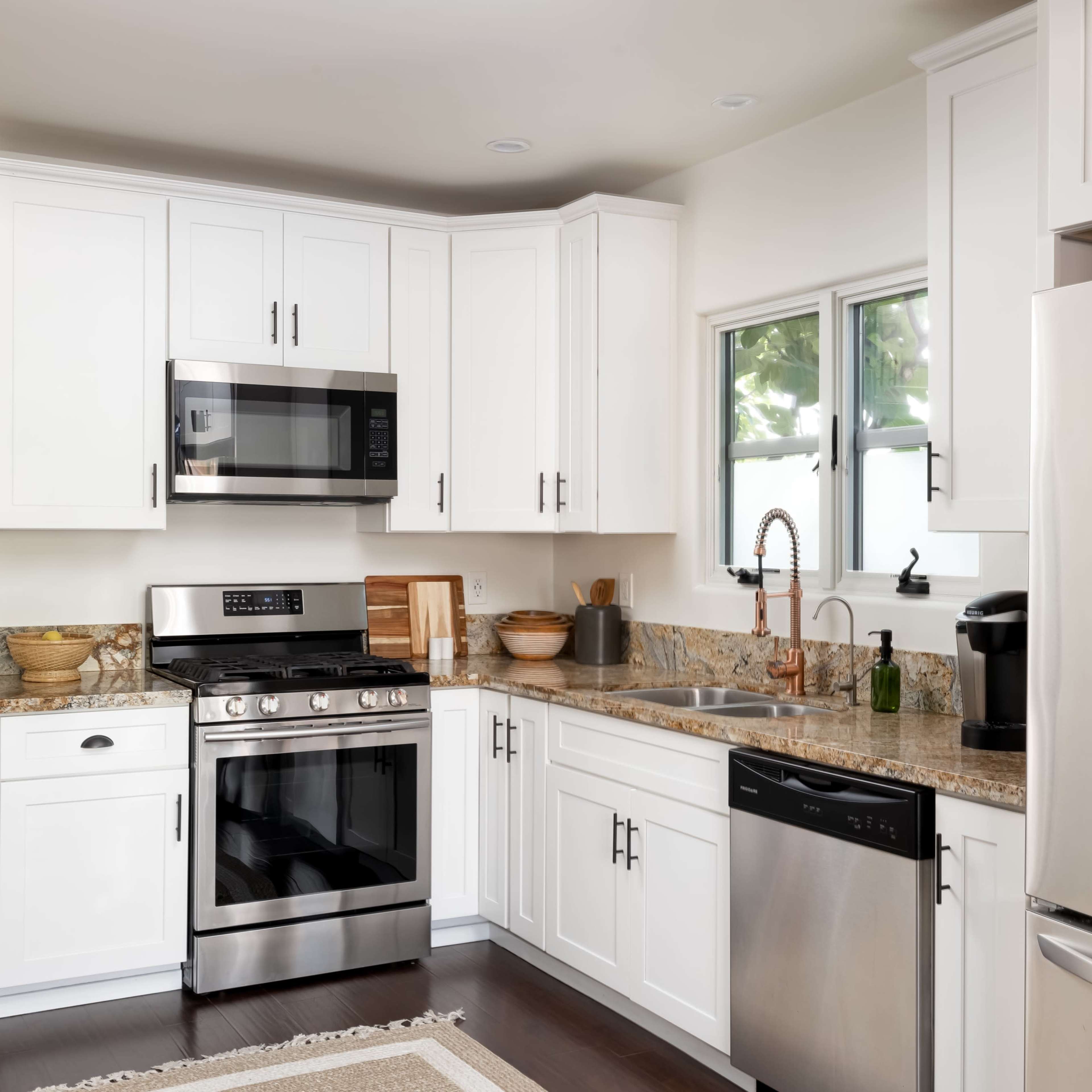 The kitchen features white cabinets, stainless steel appliances, and a granite countertop.