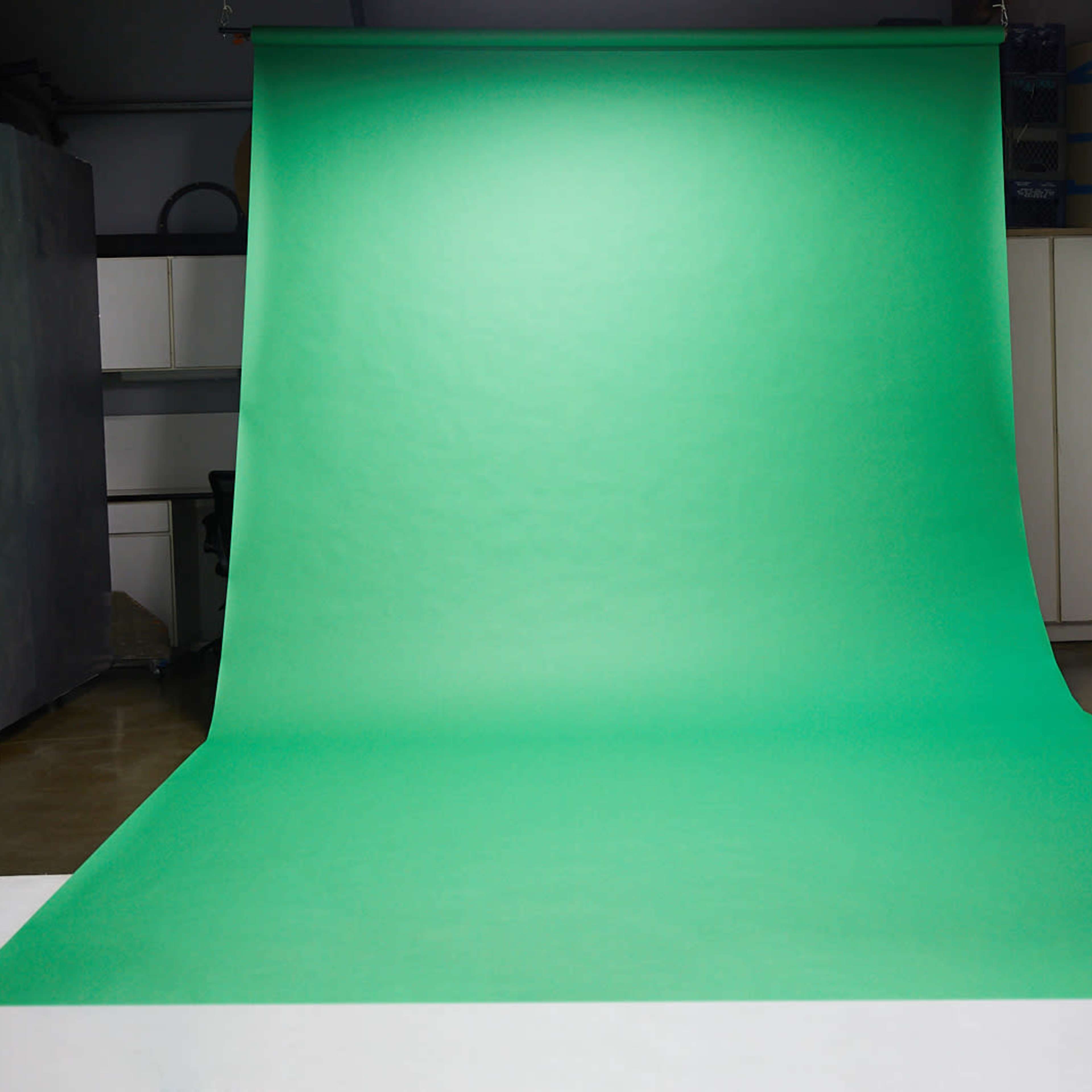 A green backdrop set up in a studio environment.