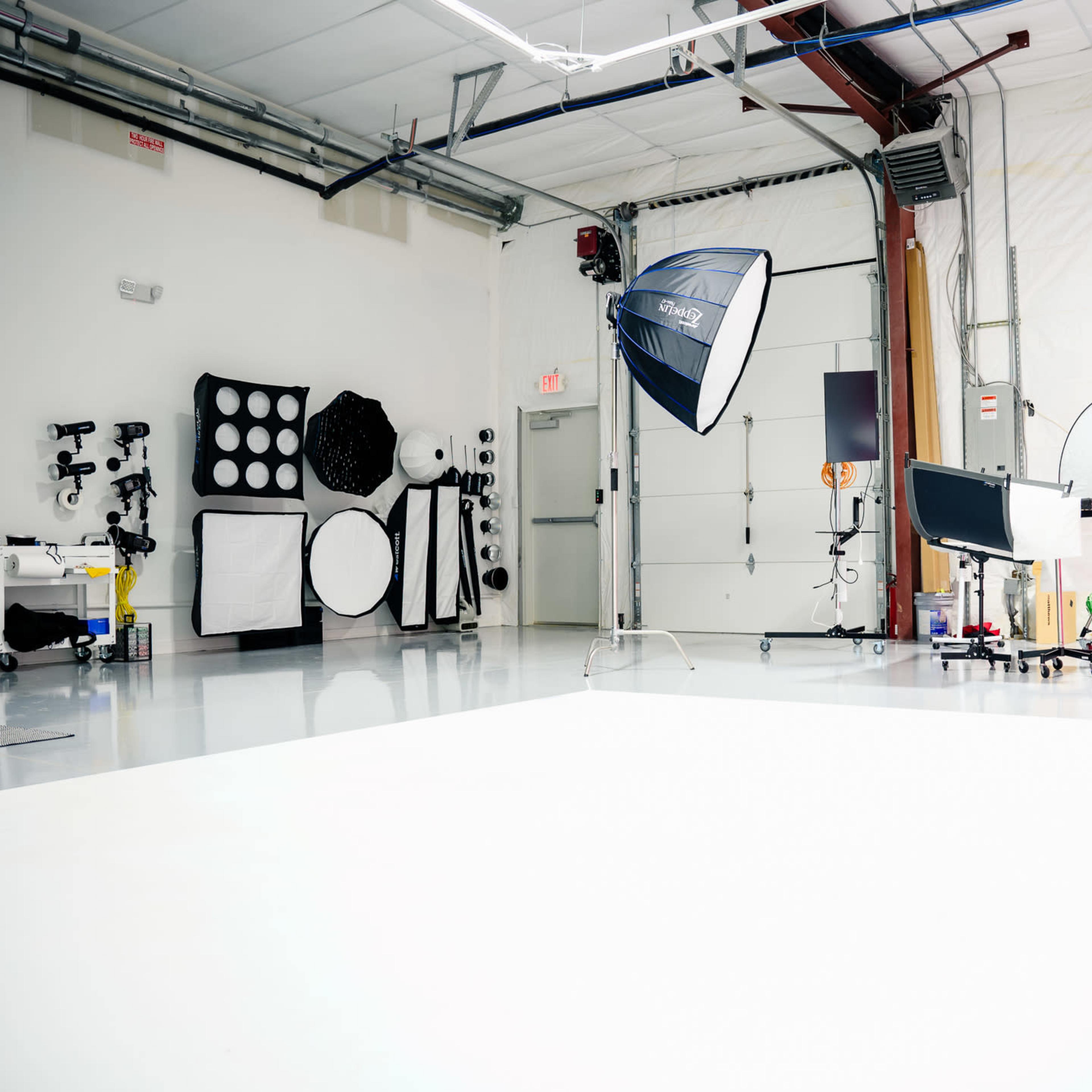 A photography studio equipped with various lighting setups, backdrops, and photography equipment.