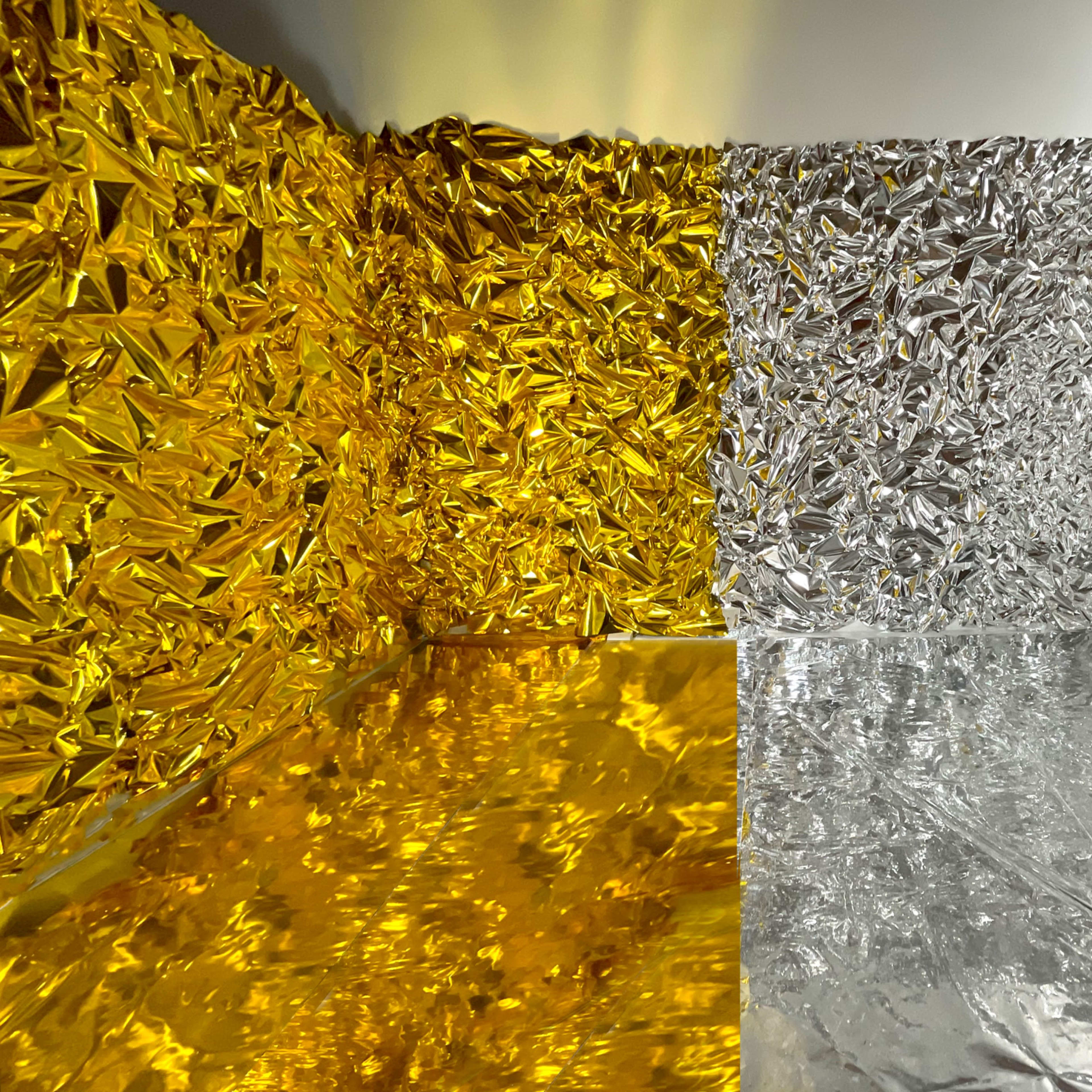 A room with walls and floor covered in crumpled golden and silver foil.