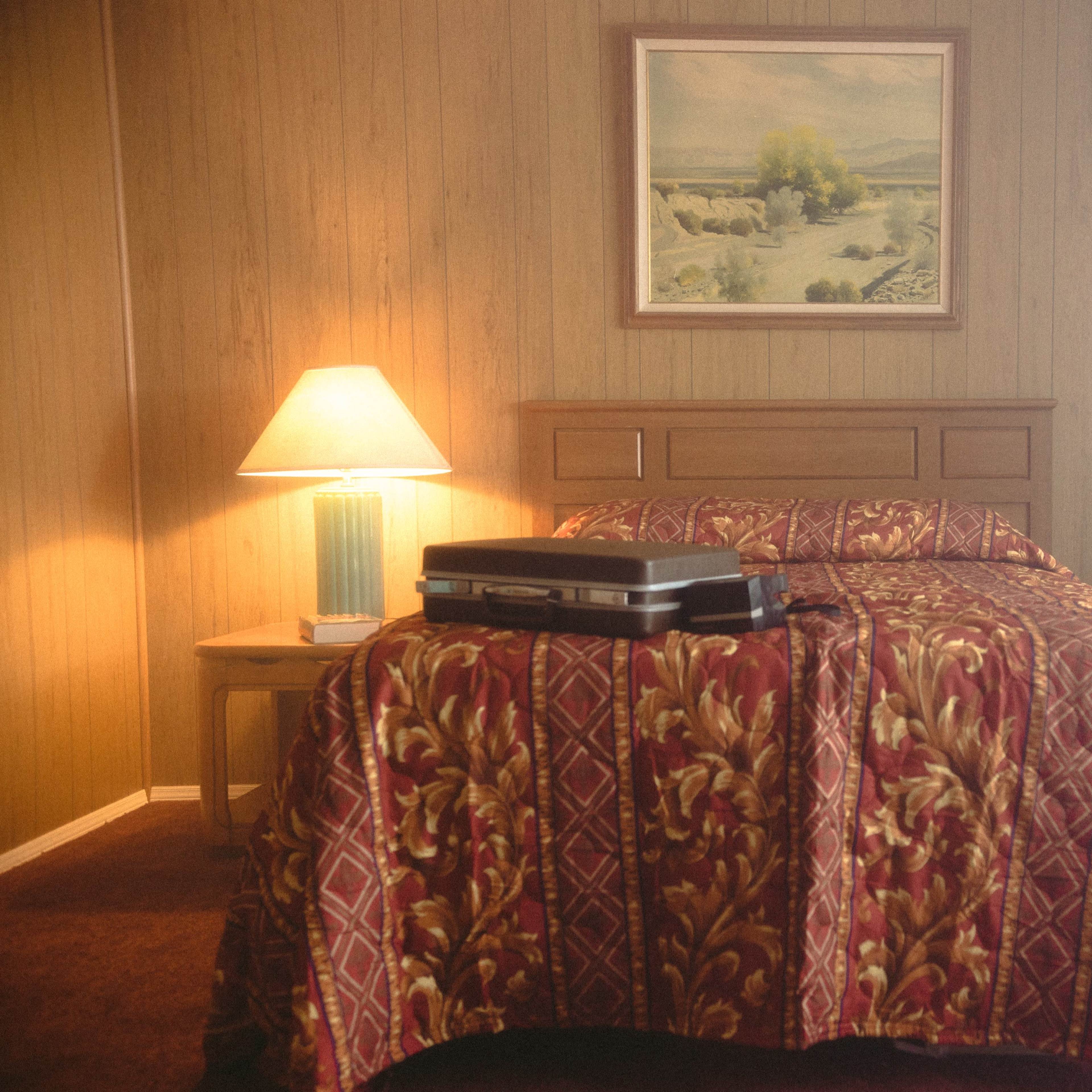 Four distinct scenes: a red-lit studio, a dimly lit area with shelves and smoke, a vintage diner with checkered flooring, and an office workspace filled with older technology.