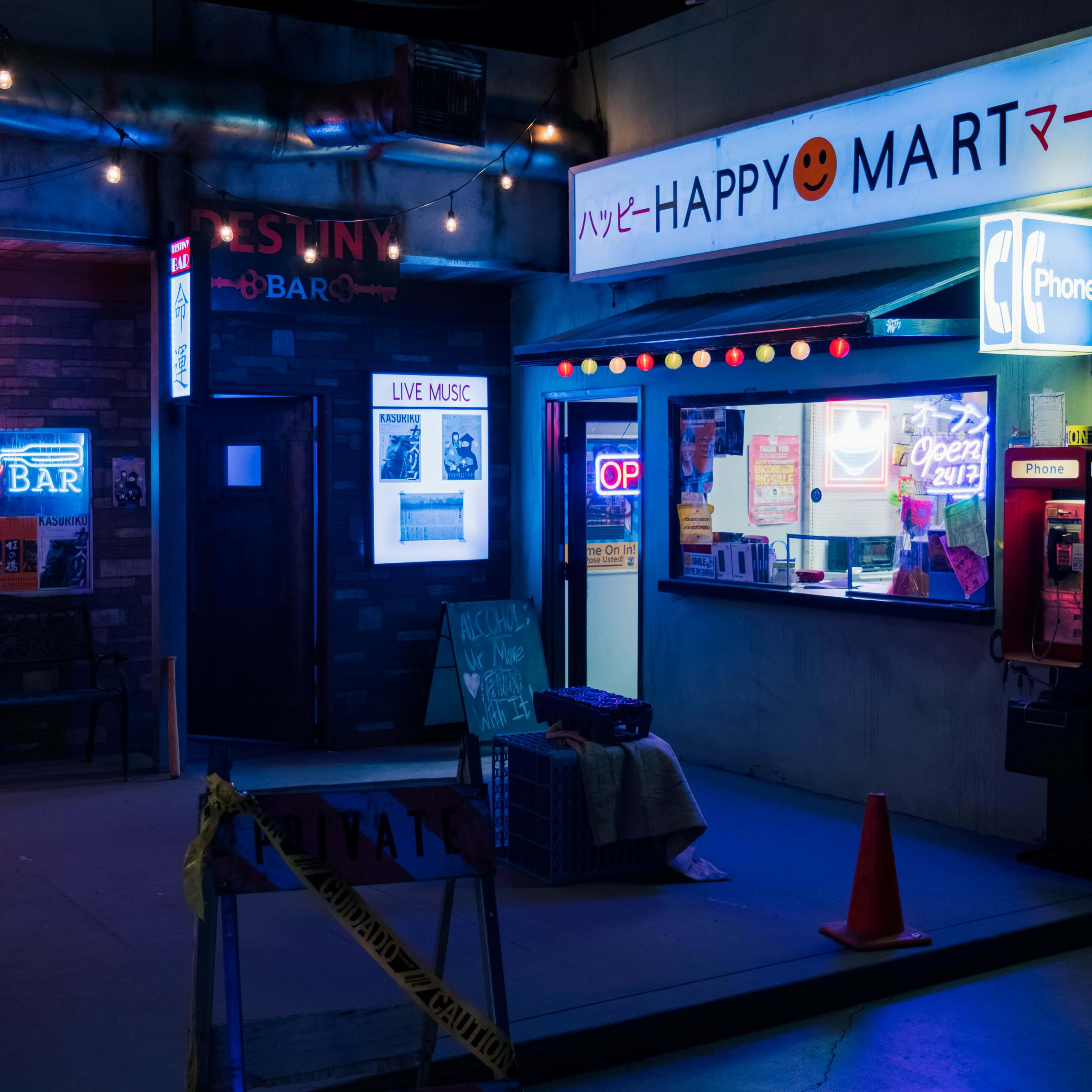 The scene features a brightly lit street corner with a store named "HAPPY MART" and a bar, surrounded by colorful neon signs and a few construction cones.
