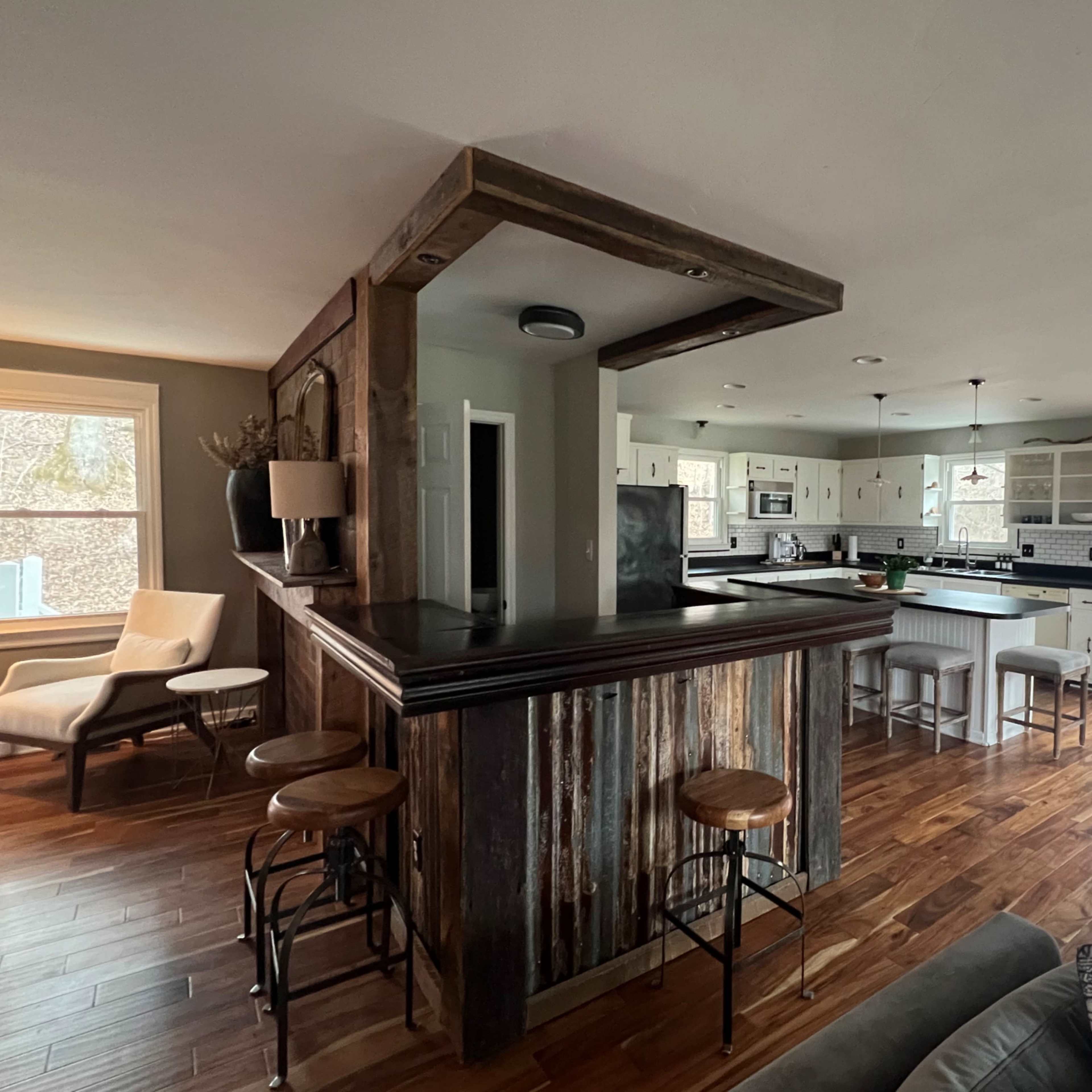 A spacious kitchen with a wooden bar area, modern appliances, and an open layout leading to a dining area.