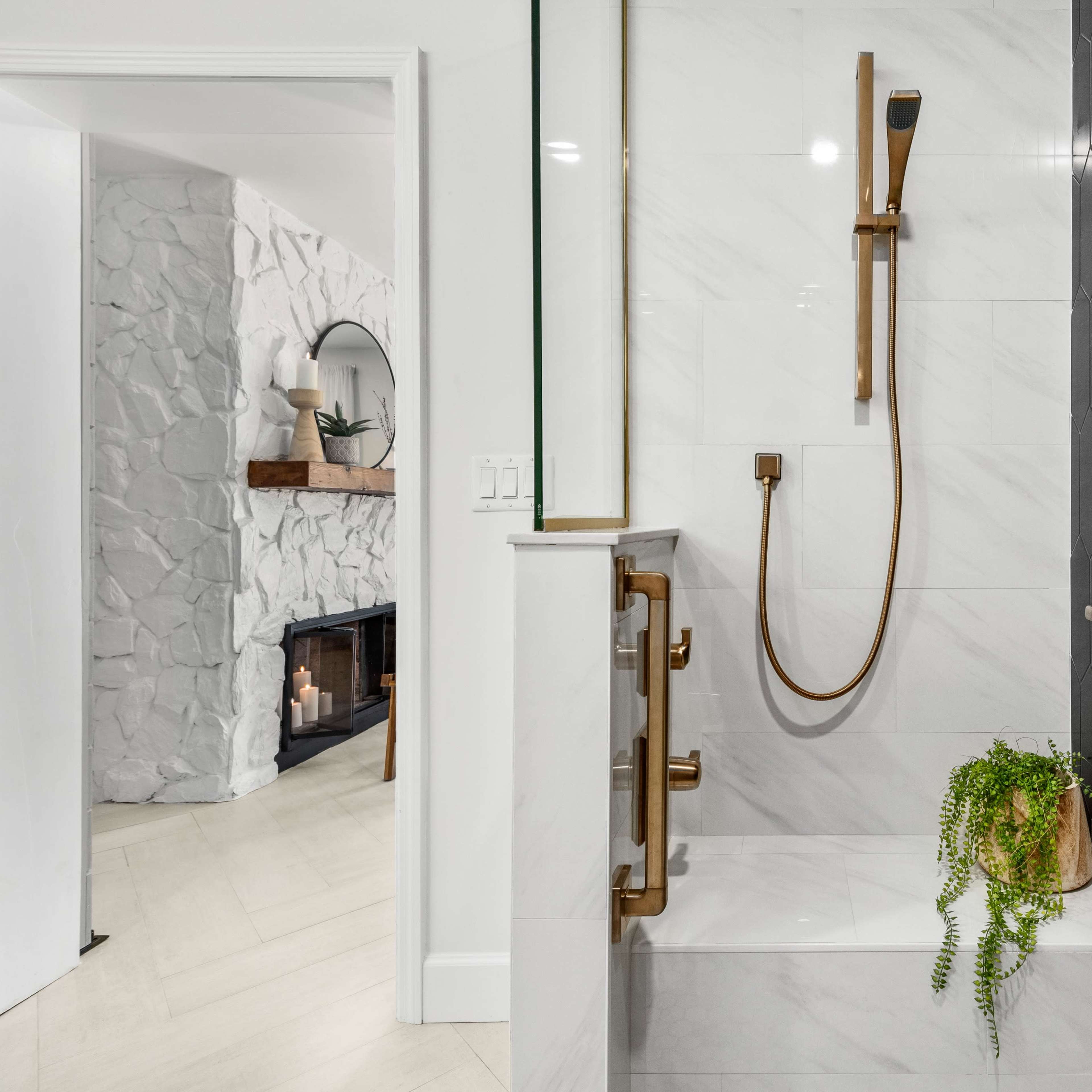 A modern bathroom with a walk-in shower showcasing a rainfall showerhead, sleek fixtures, and a black hexagonal accent wall.