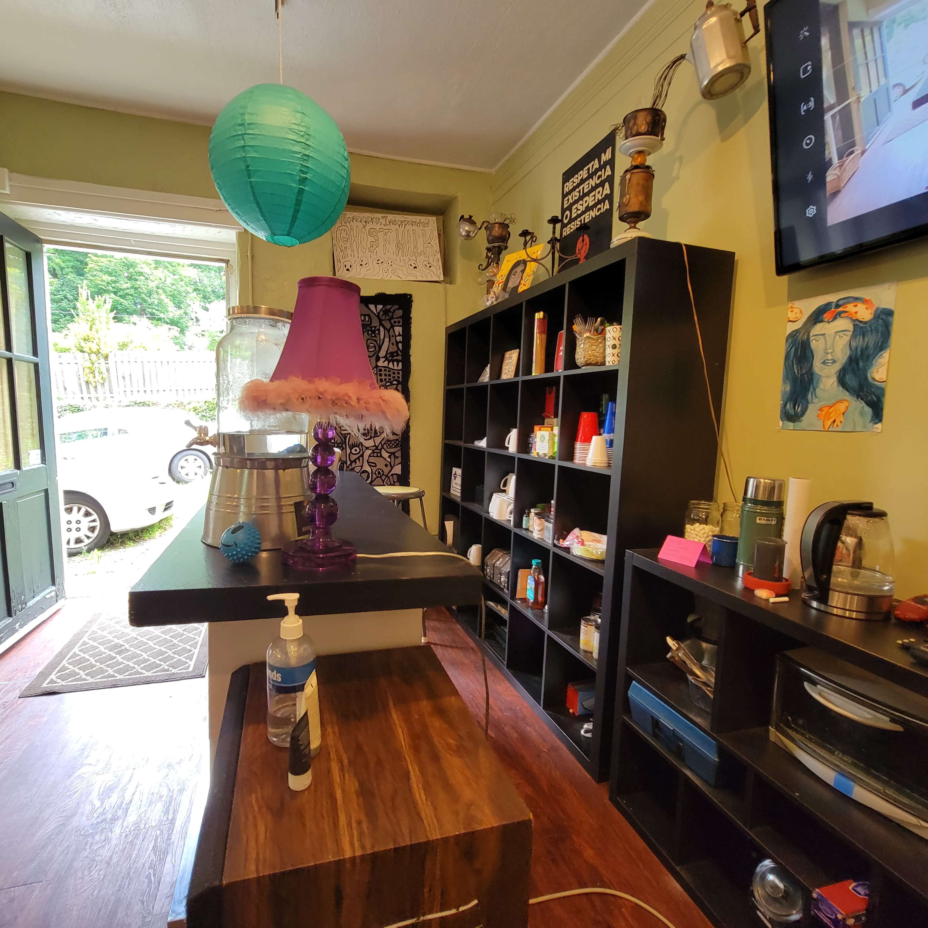 A brightly colored room with a wooden counter, shelves filled with various items, and a door leading outside.