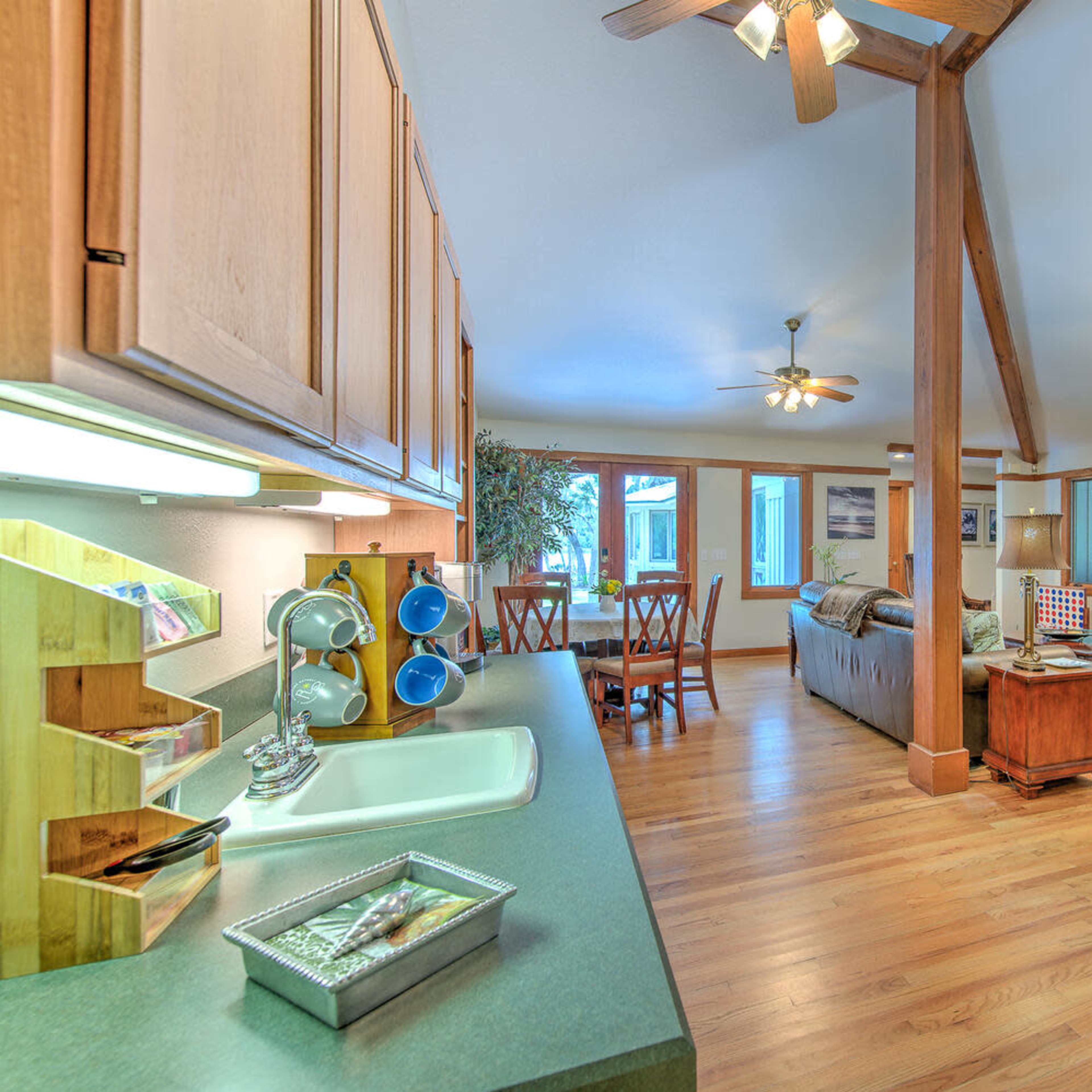 An open-concept living area with a kitchen, dining space, and seating area featuring wood accents and large windows.
