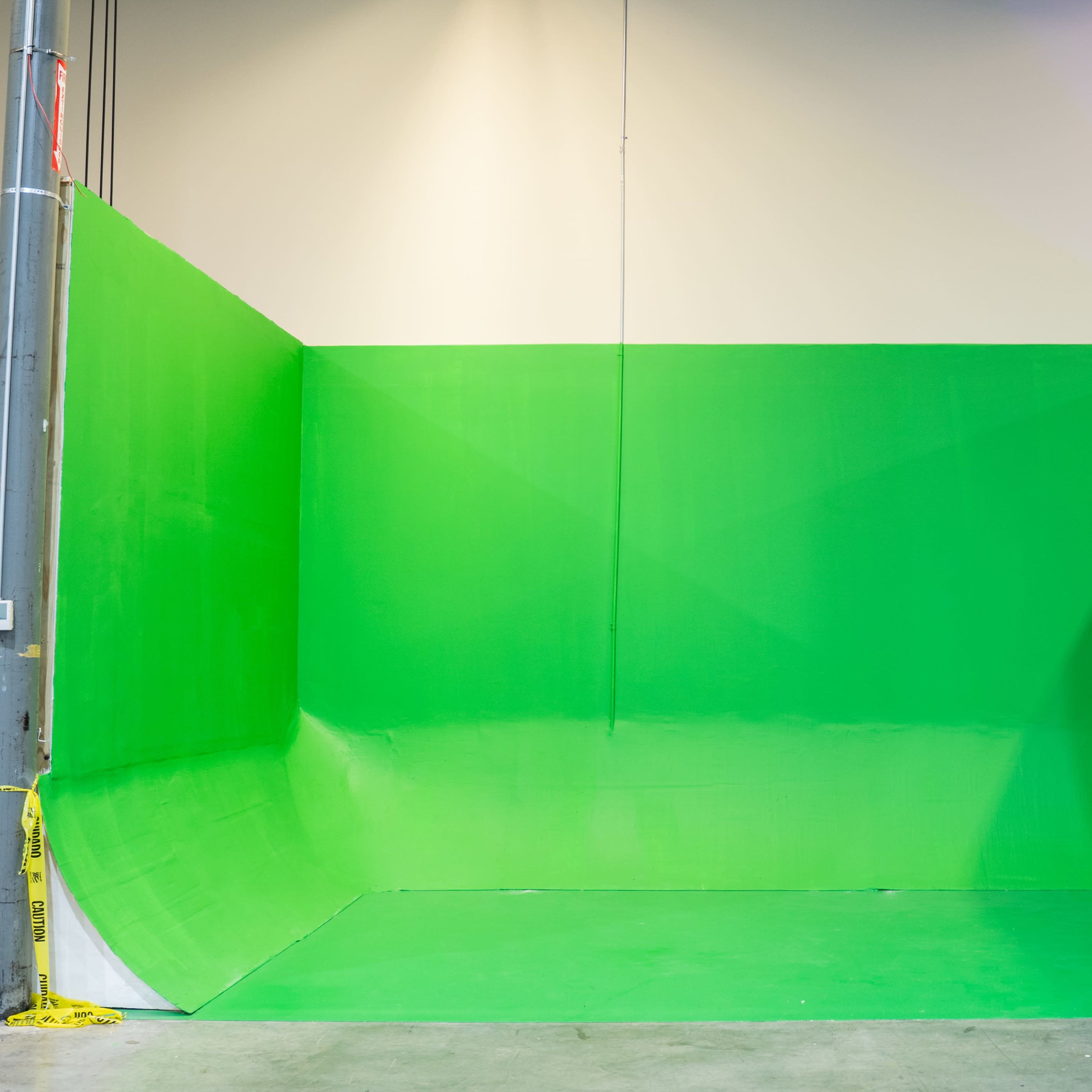 A green studio space with green walls and a curved green floor, commonly used for green screen filming.