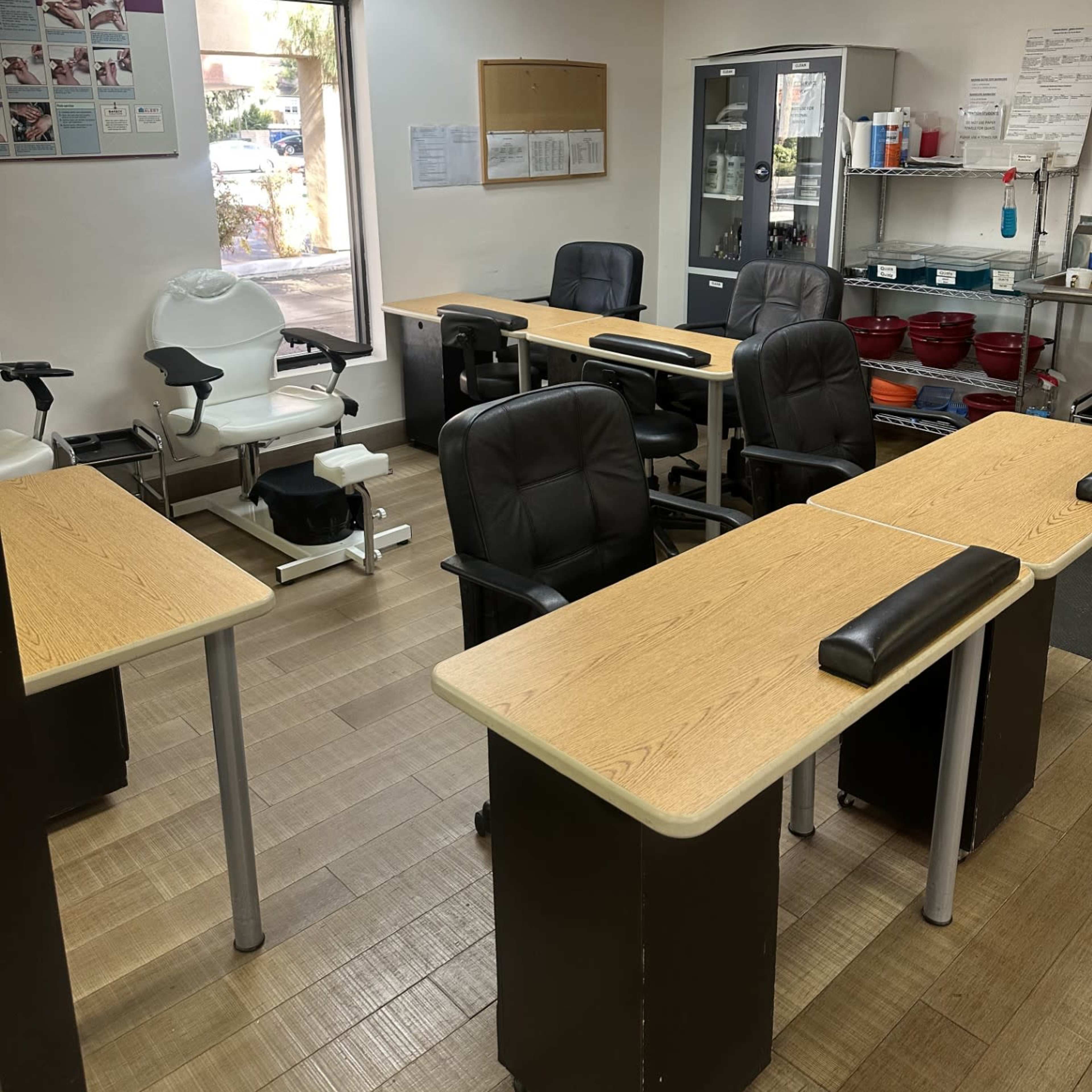 A salon or spa room with several workstations, each equipped with a chair and a table.