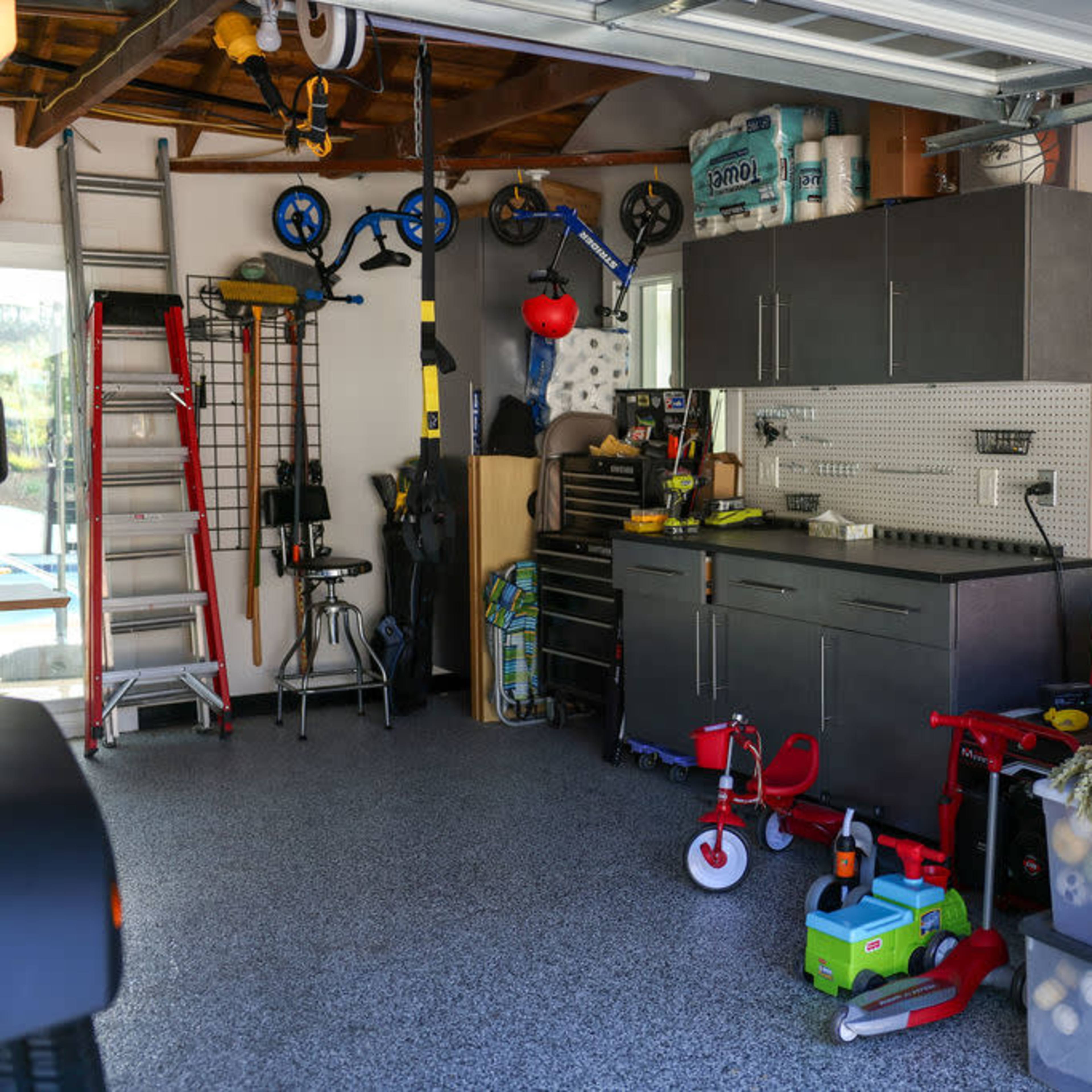 A garage with organized storage, including shelves, tools, and various equipment.