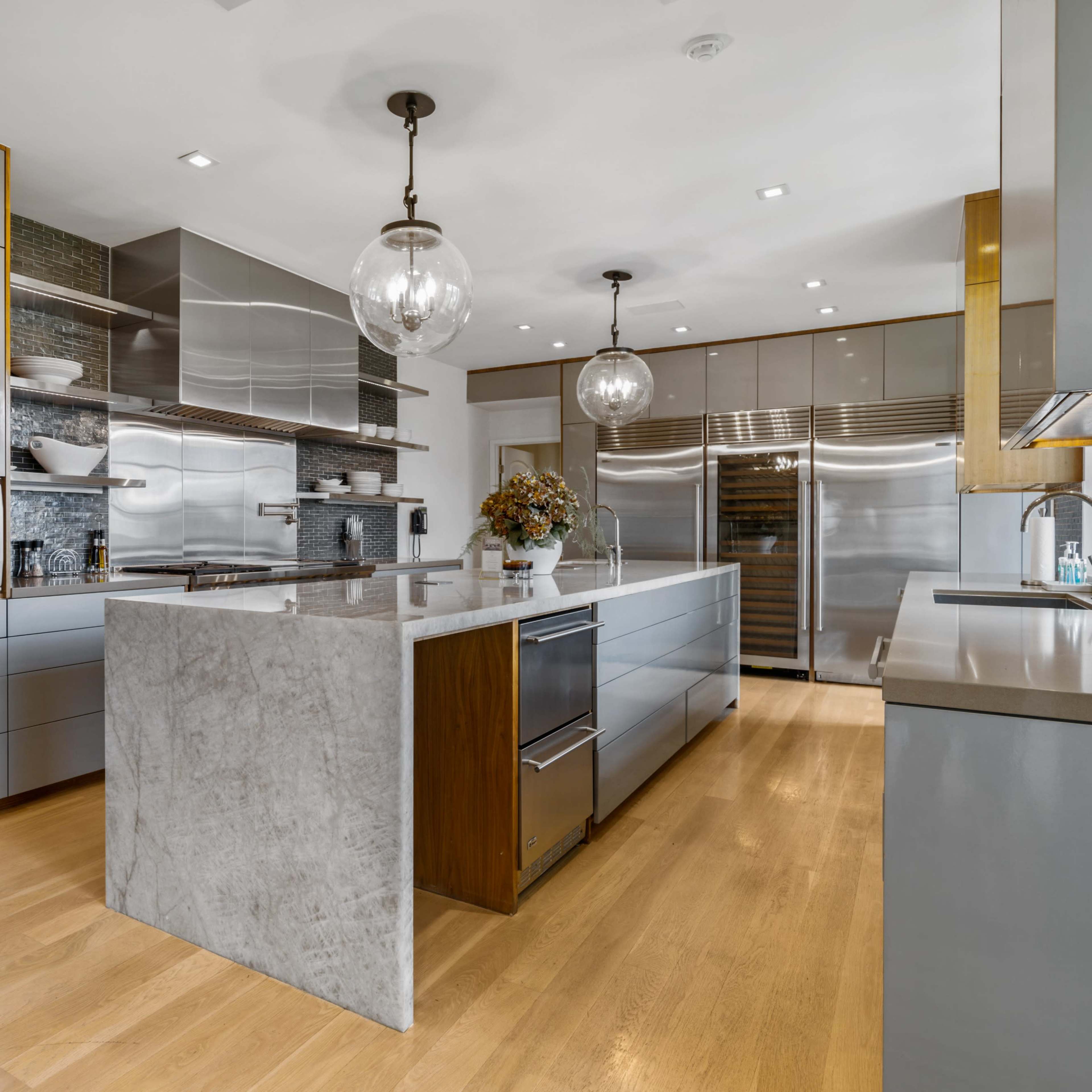A modern kitchen featuring sleek cabinetry, a central island with a stone countertop, and stainless steel appliances.