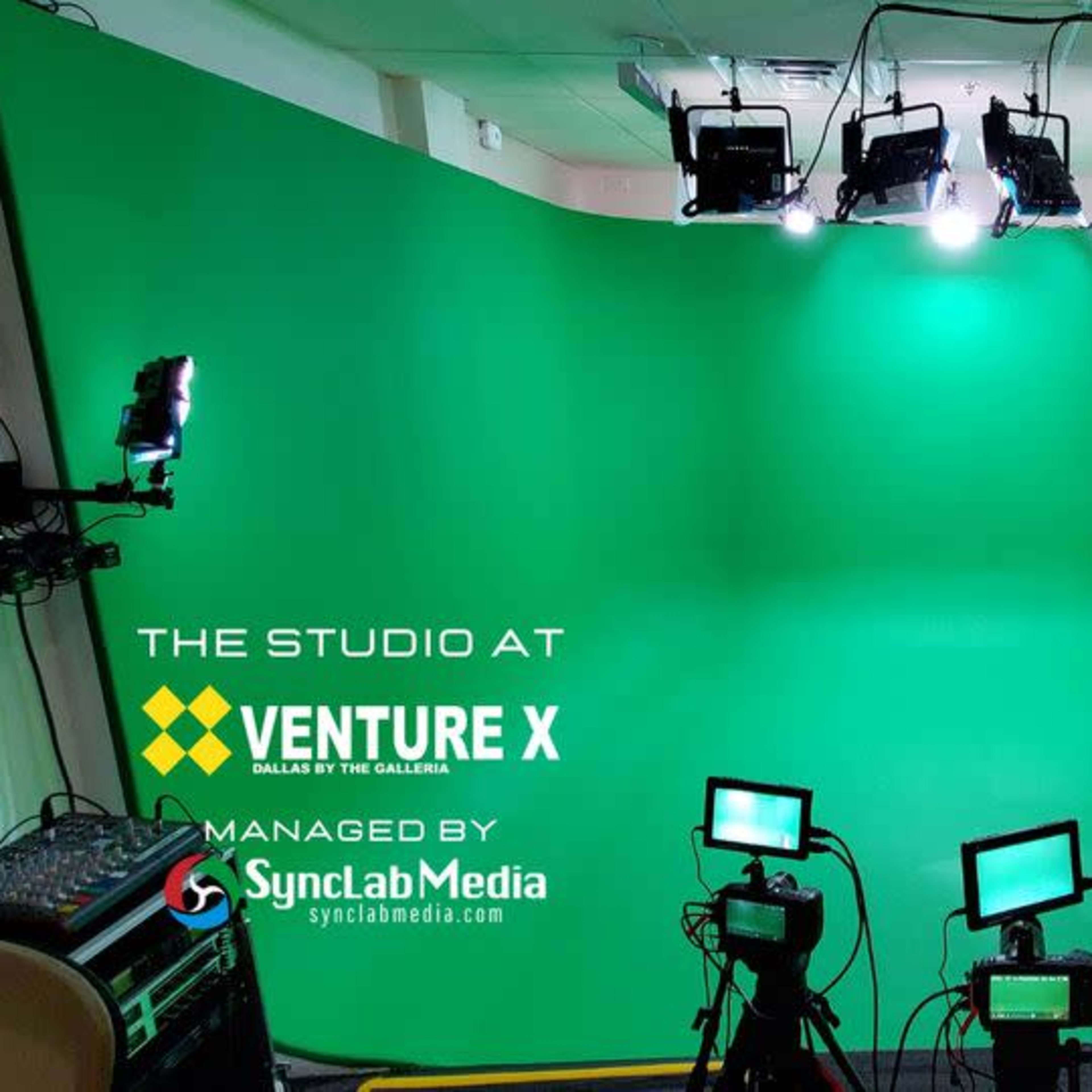 A green screen studio space equipped with multiple lights and cameras.