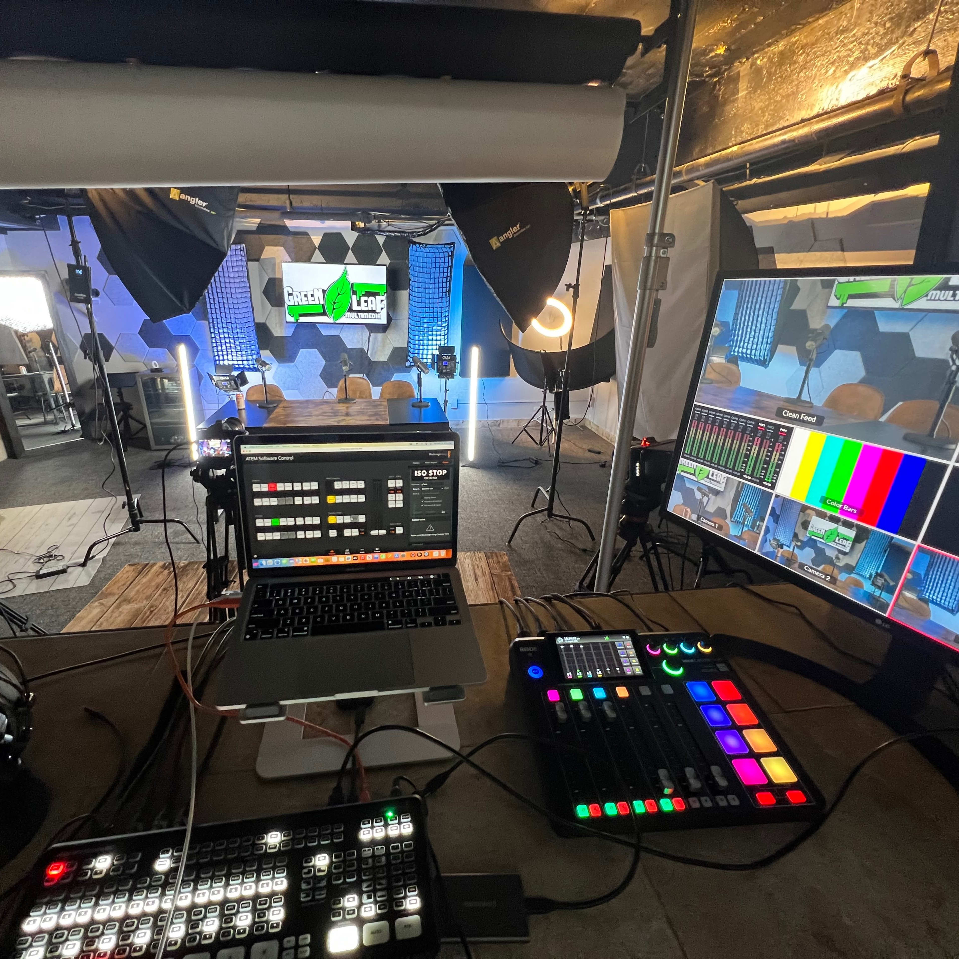 A production studio equipped with cameras, lighting, a mixing console, and multiple screens displaying live video feeds.