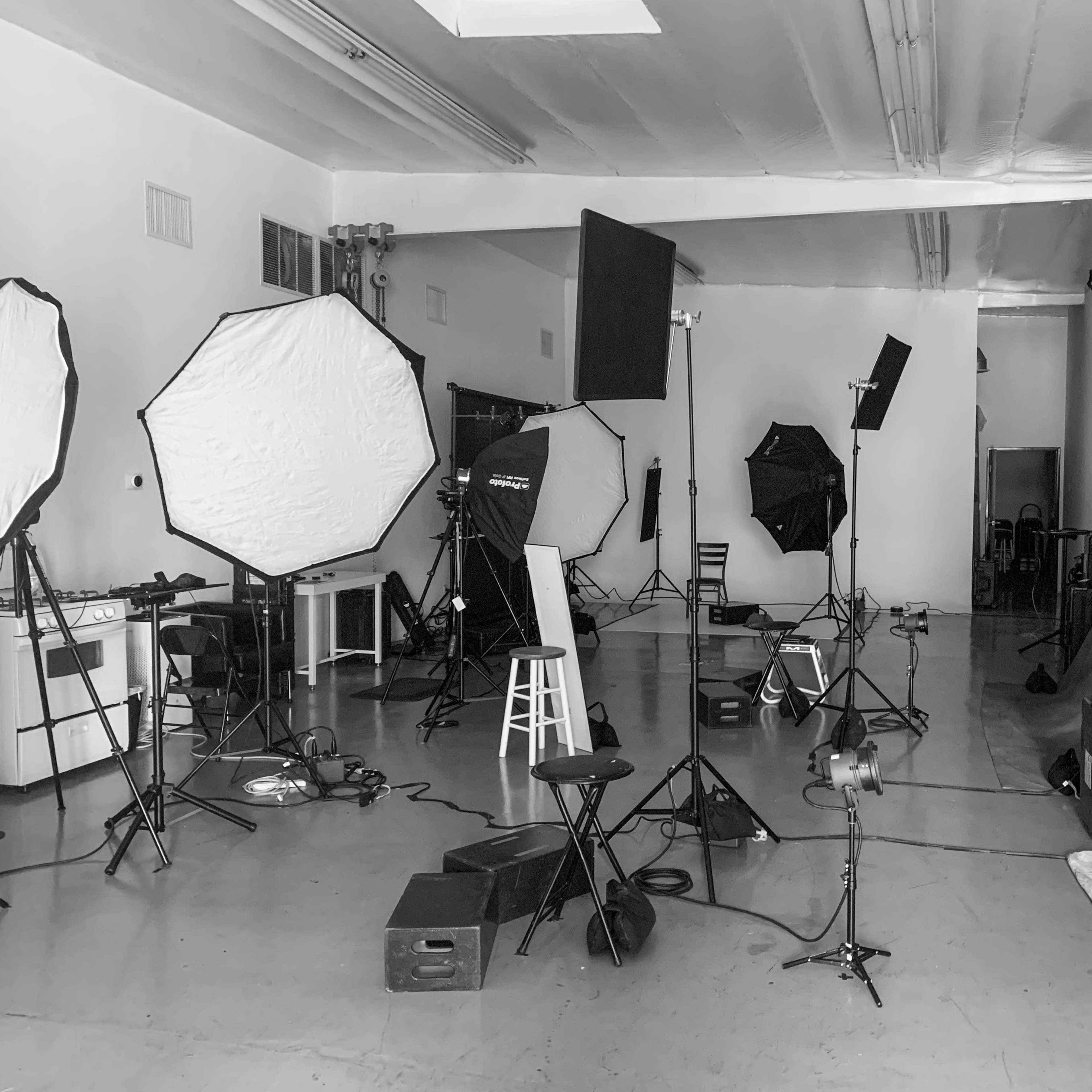 A photography studio filled with various lighting equipment, backdrops, and seating arranged for a photoshoot.
