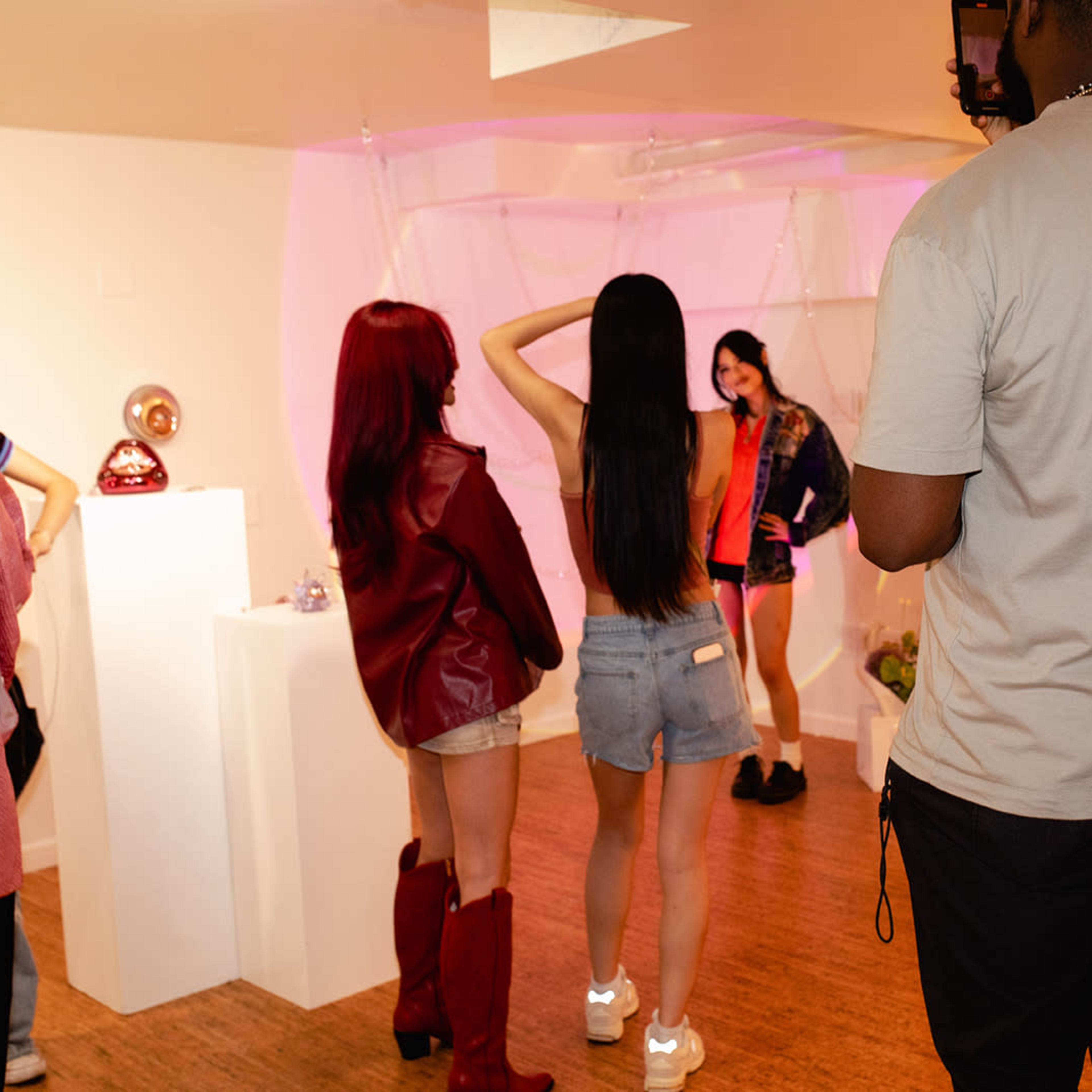 A group of people poses and interacts in a brightly lit exhibition space featuring decorative displays.