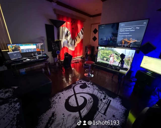 The image shows a colorful home entertainment setup with multiple screens, a musical note-patterned rug, and red curtains in a room.