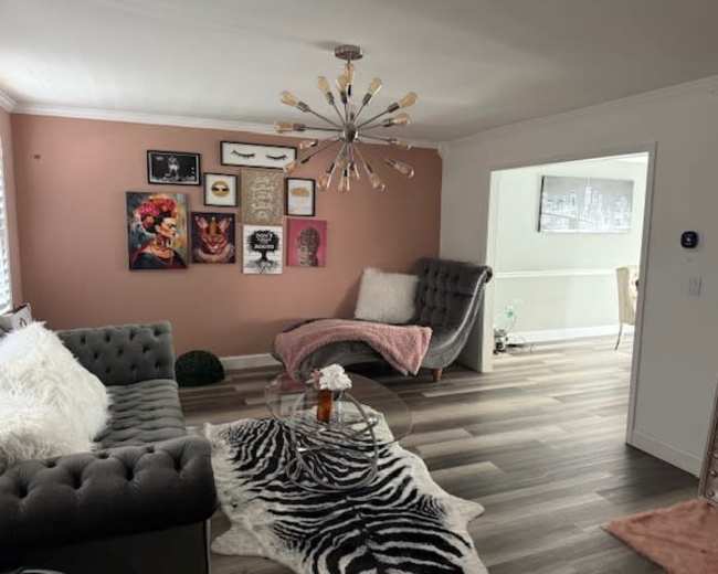 The image shows a modern living room with a gray sectional sofa, a coffee table, and a decorated wall featuring various art pieces.