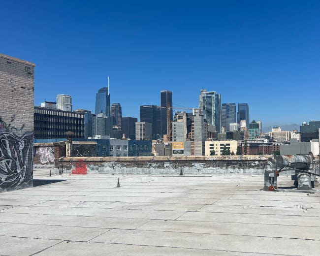 A rooftop view of a city skyline with modern skyscrapers against a blue sky.